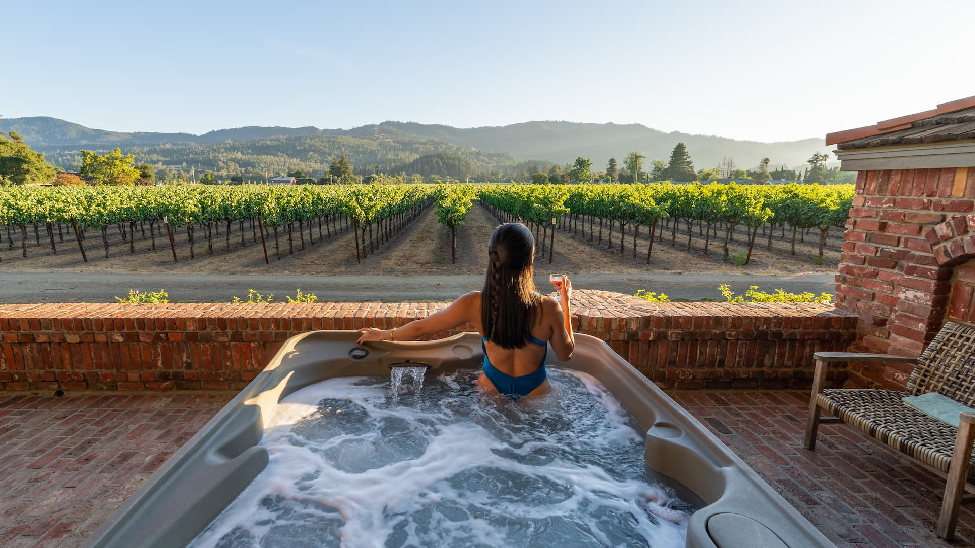 Woman in hot tub with vineyard view