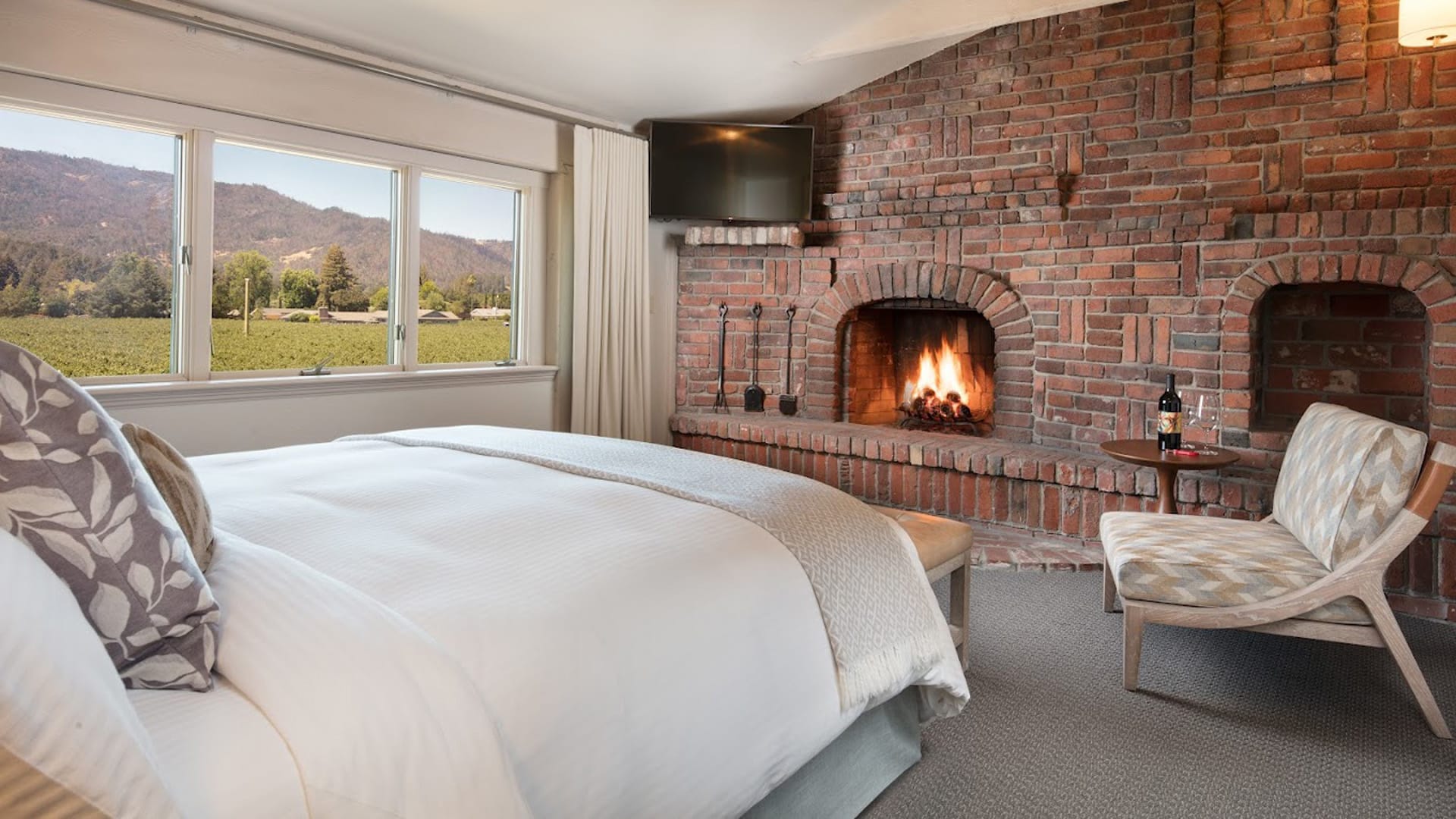 Cozy bedroom with fireplace and mountain view.