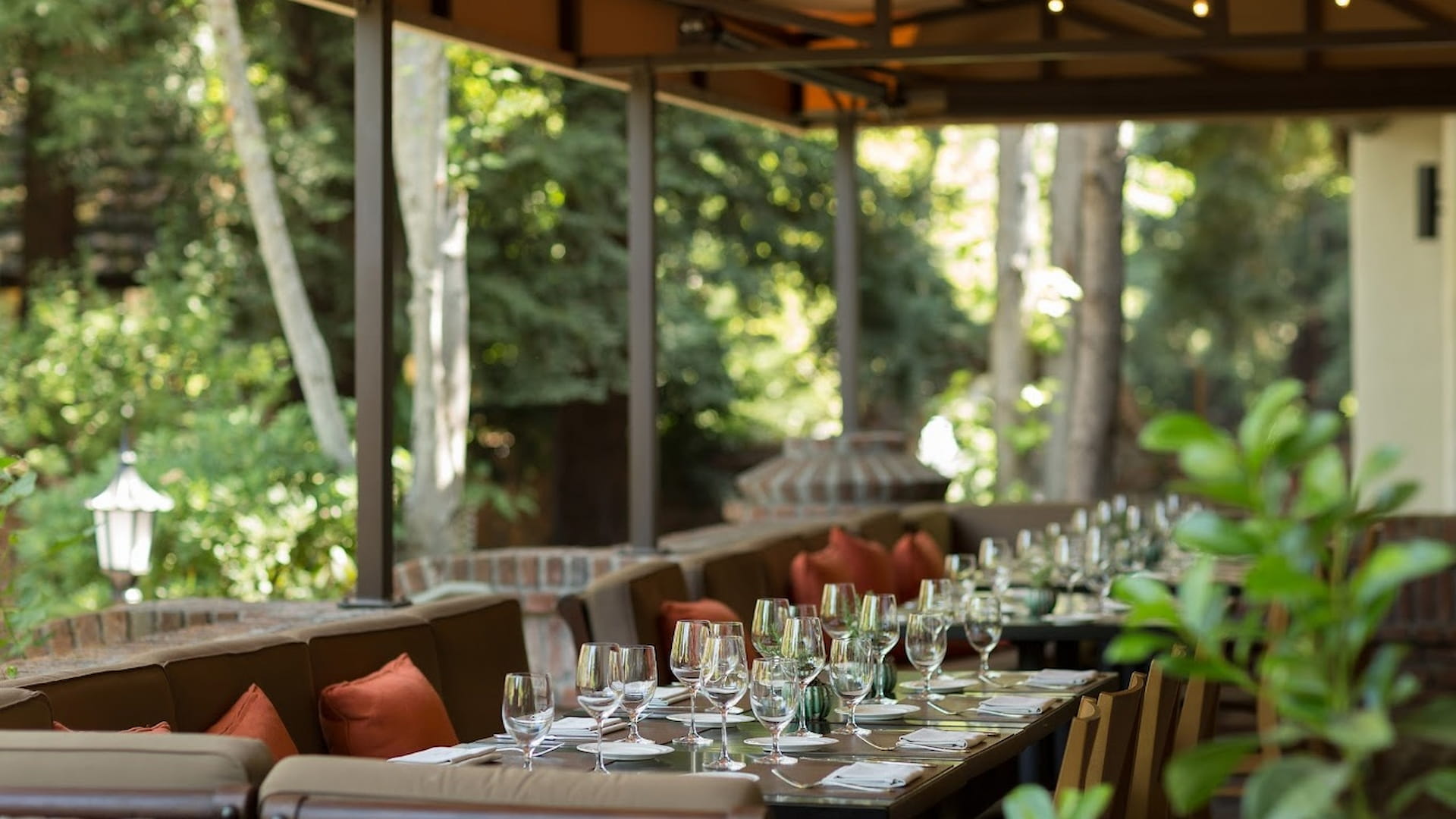 Outdoor restaurant seating with glasses and cushions