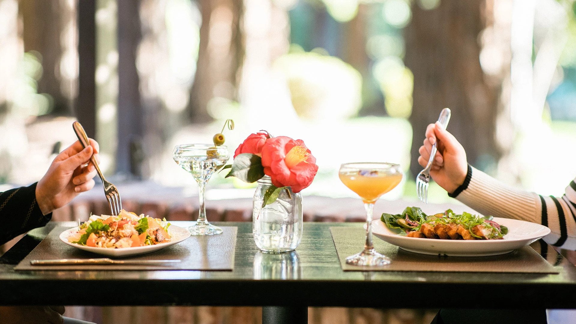 Outdoor dining with salads and cocktails