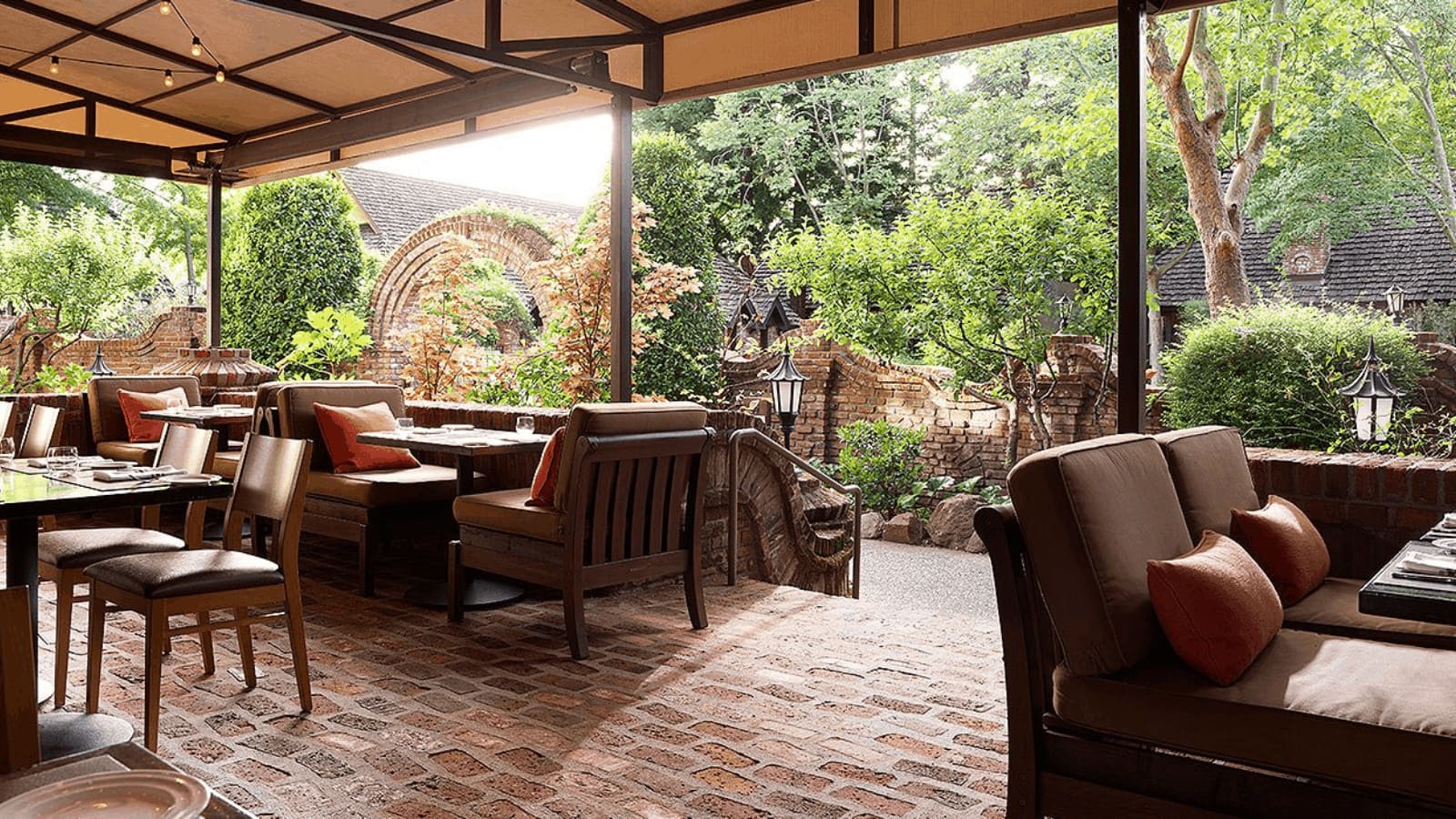 Outdoor restaurant patio with lush greenery and seating