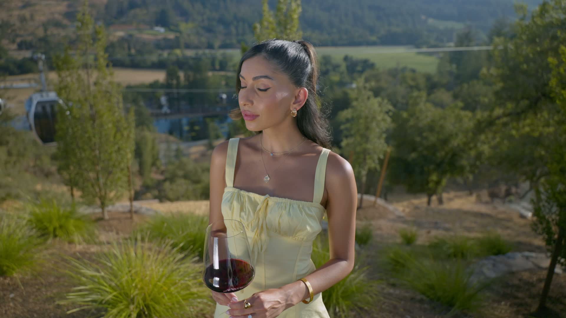 Woman in yellow dress holding glass of red wine