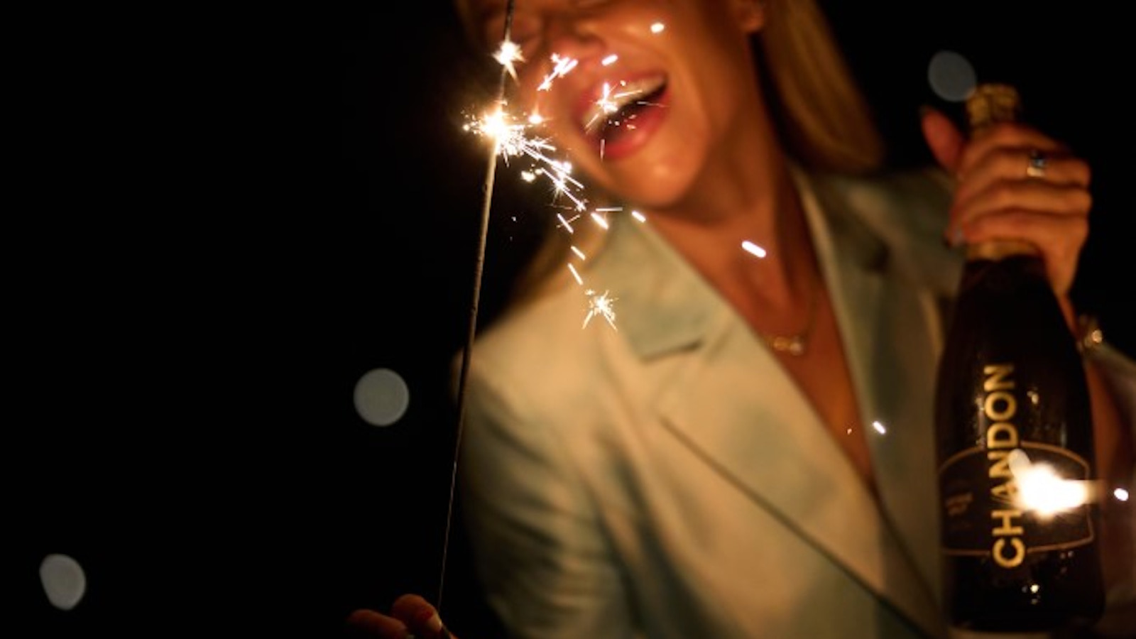 Person celebrating with sparkler and Chandon bottle