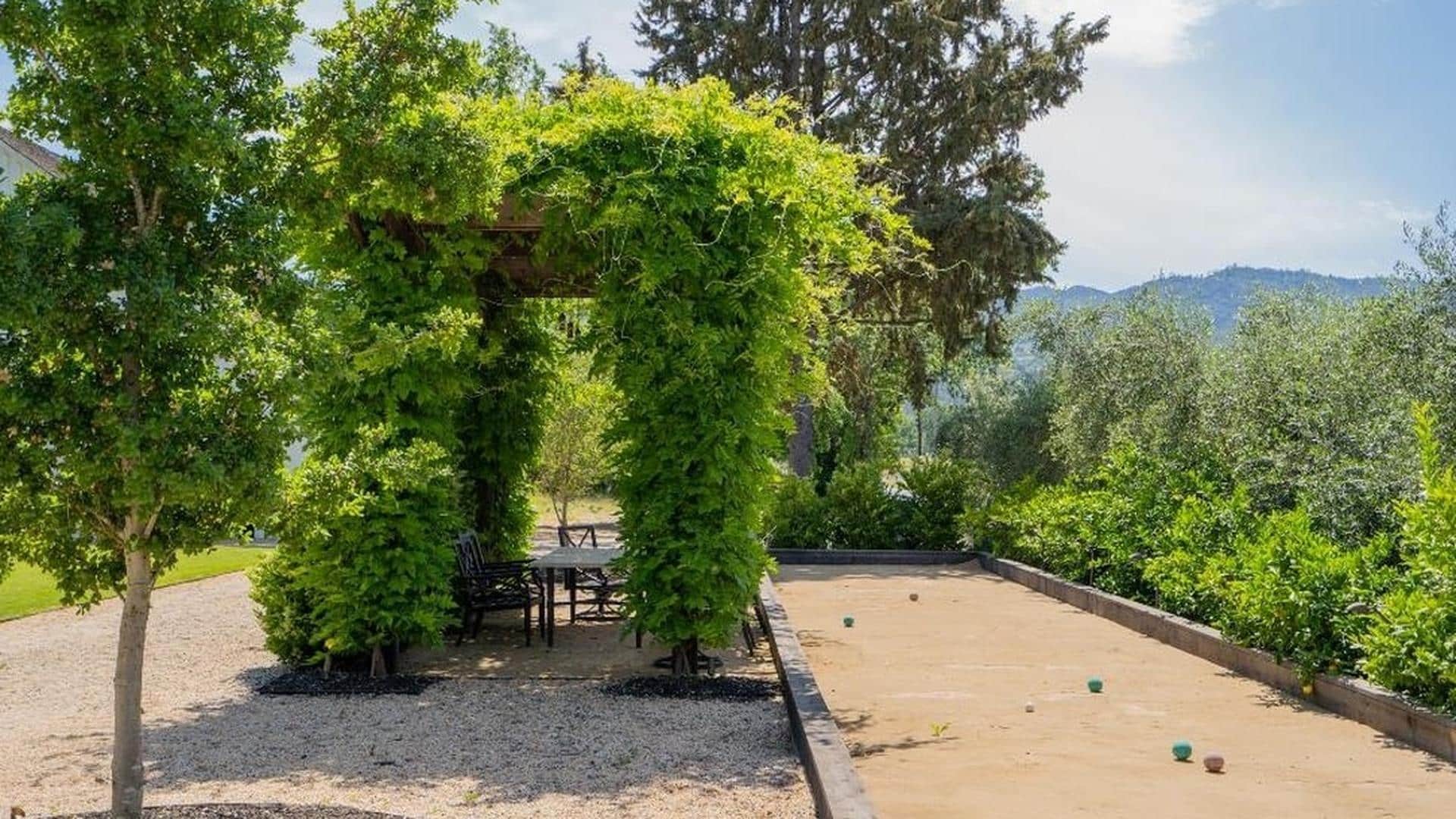 Lush garden with pergola and bocce court.
