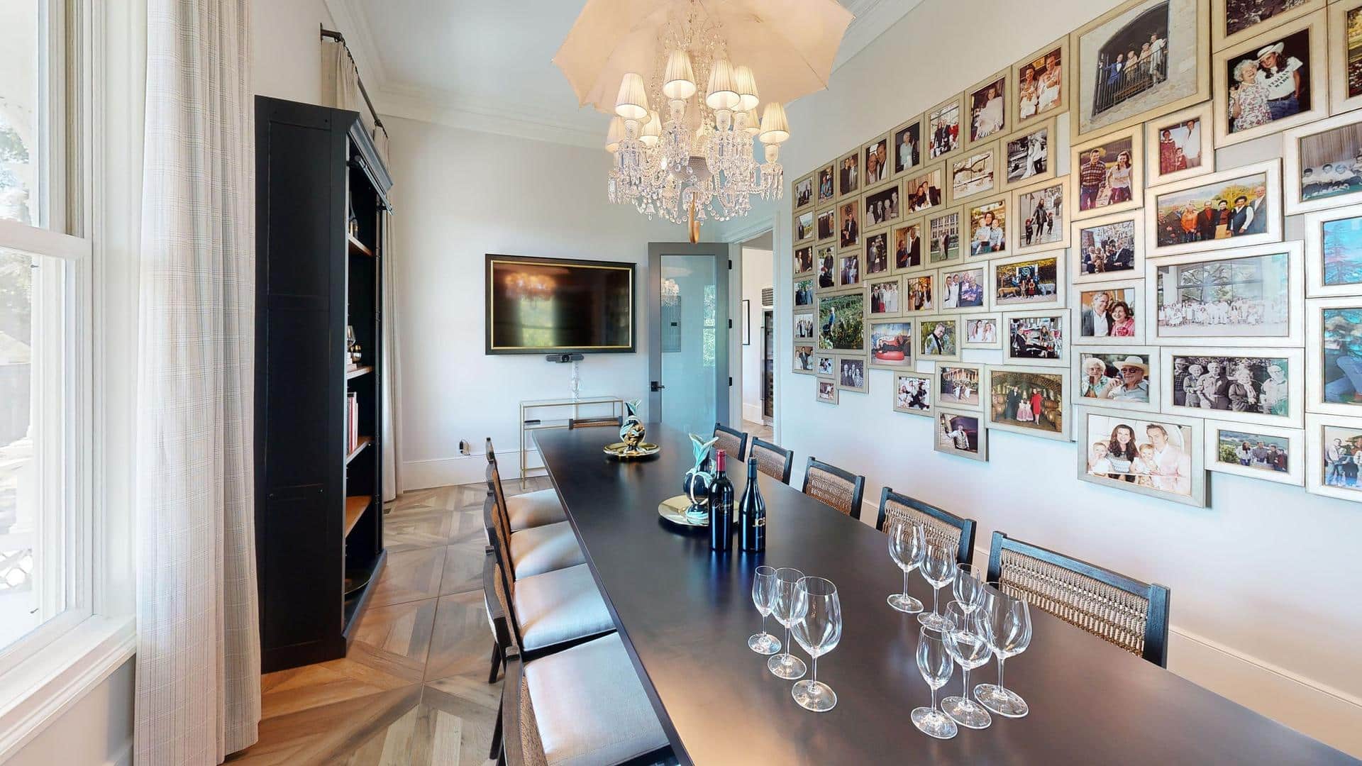 Dining room with photo wall and chandelier.