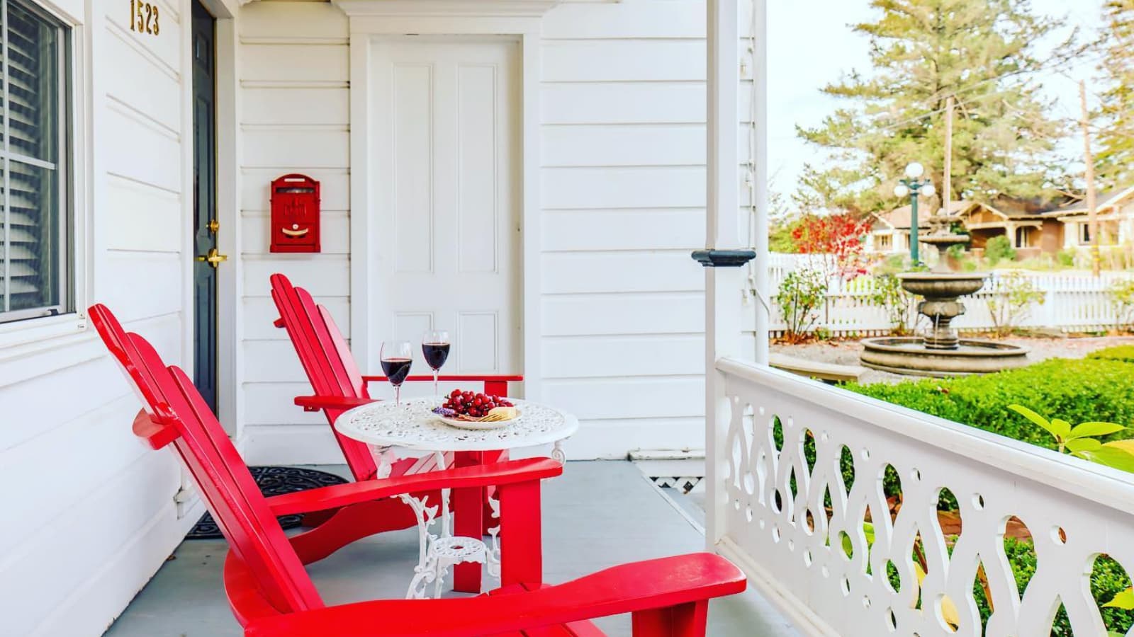 Red chairs on porch with wine and snacks