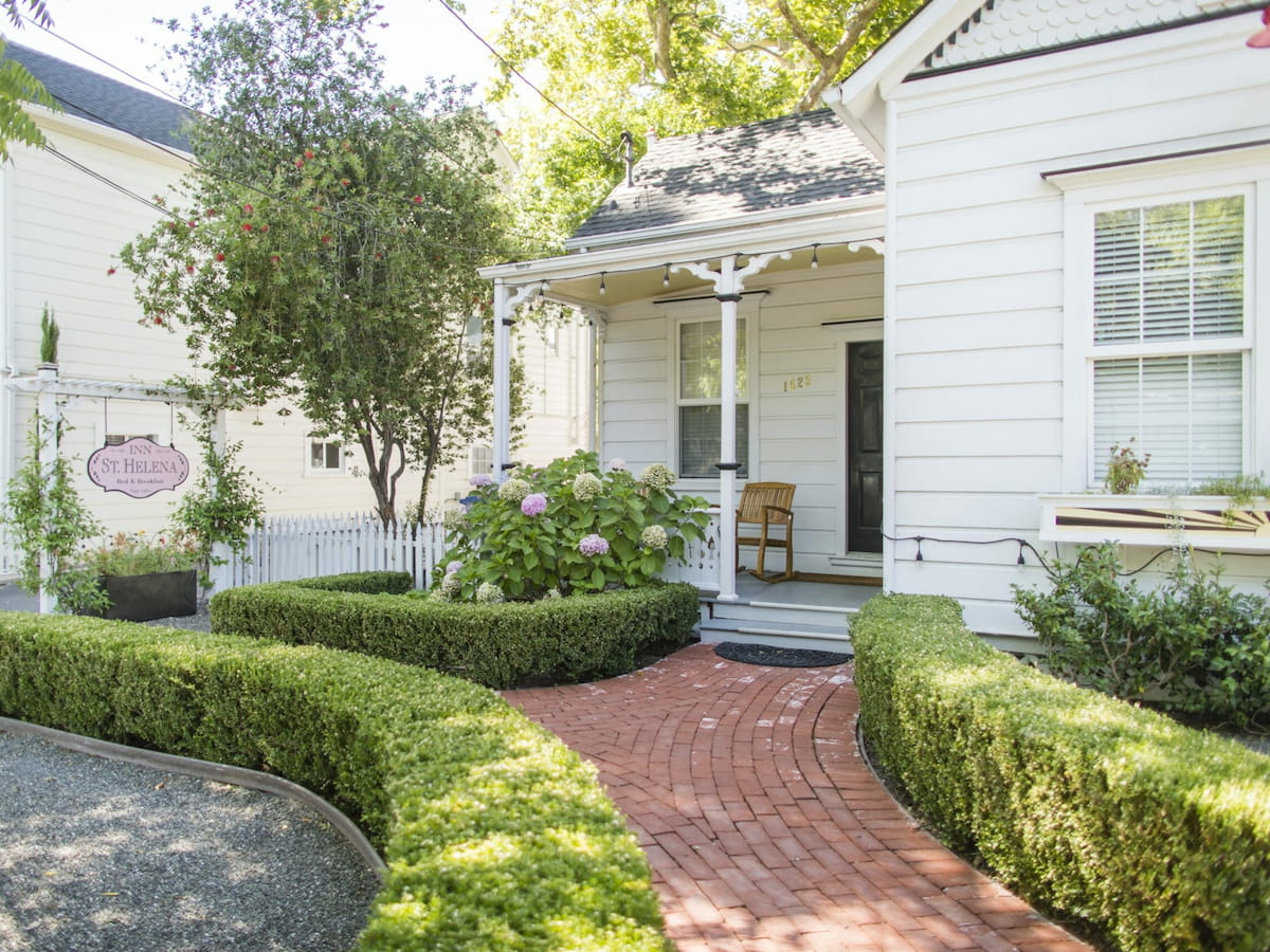 Charming white house with garden and pathway.