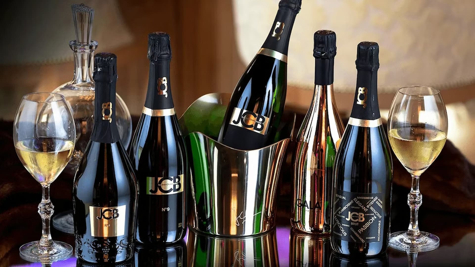 Assorted JCB wine bottles and glasses on display.