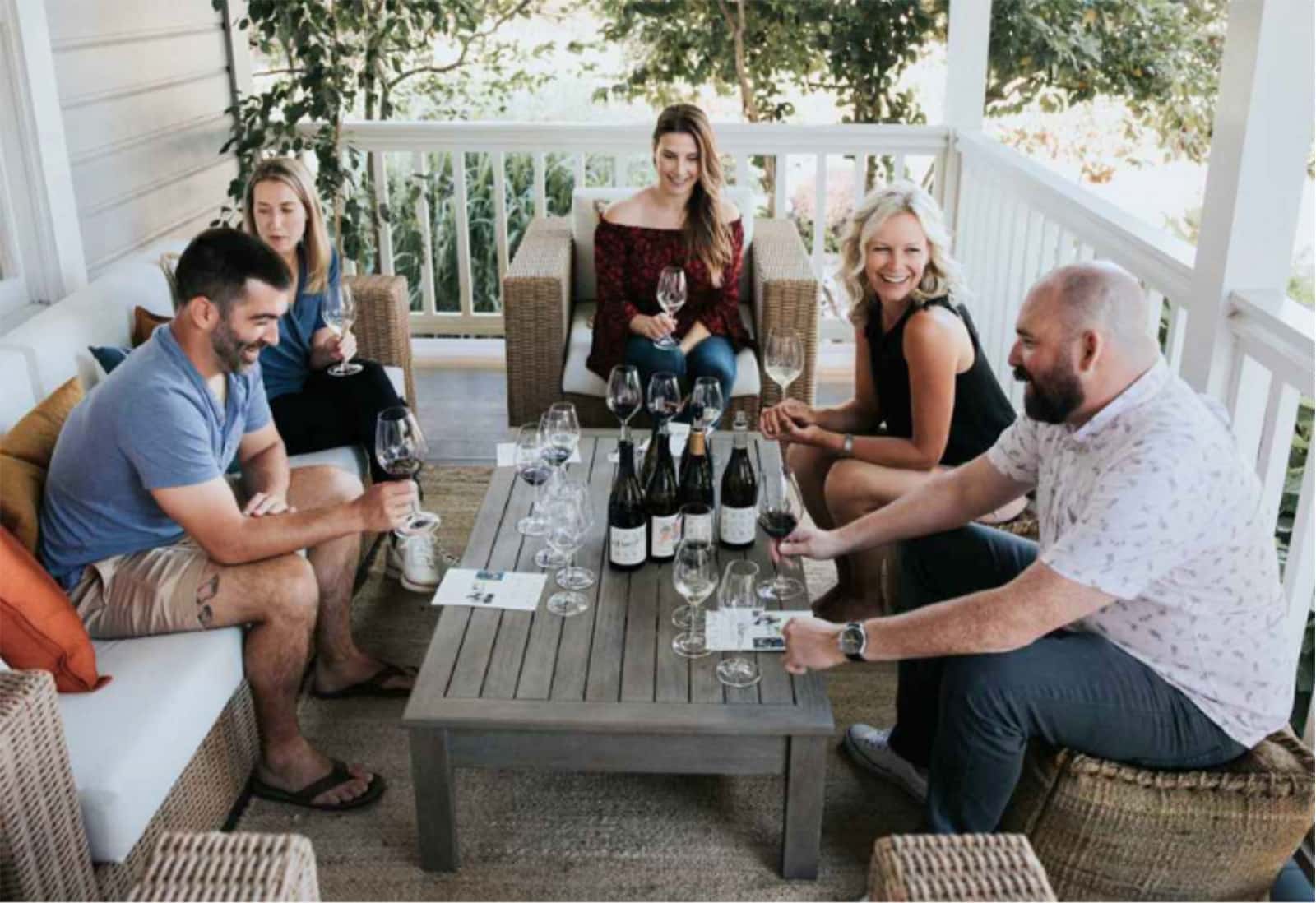 Friends enjoying wine on porch gathering.