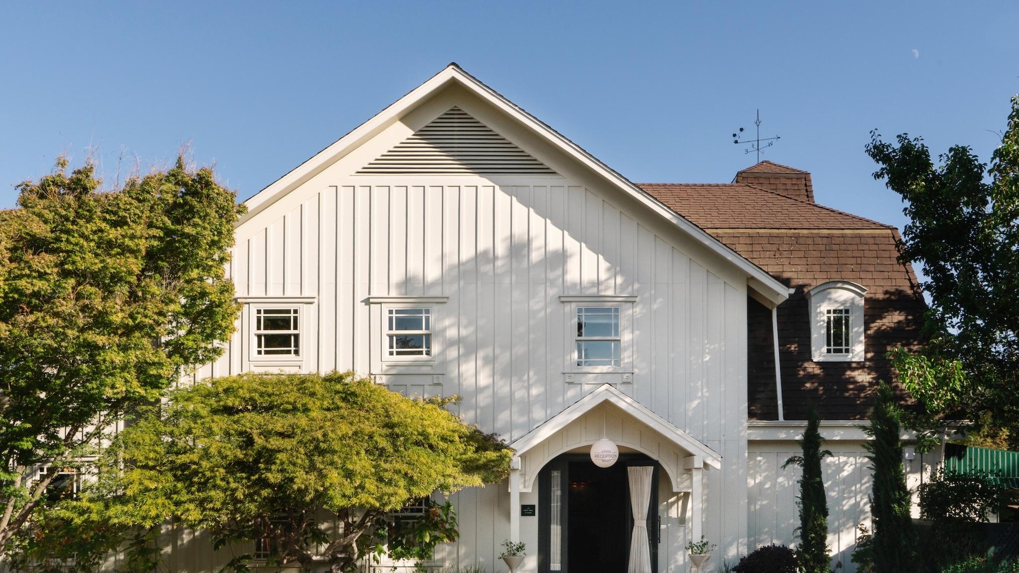 Charming white house with trees and blue sky