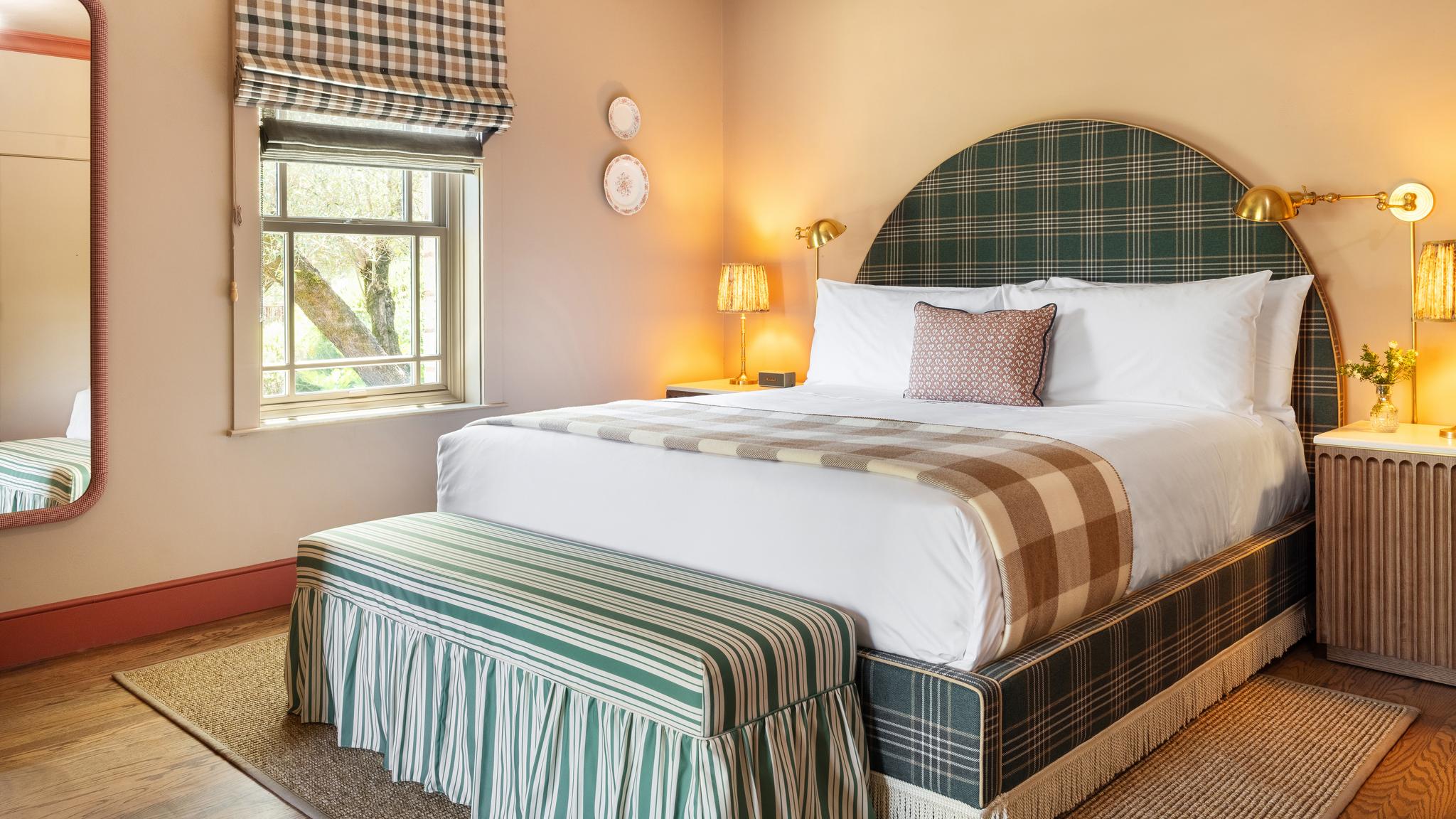Cozy bedroom with plaid bed and window view.