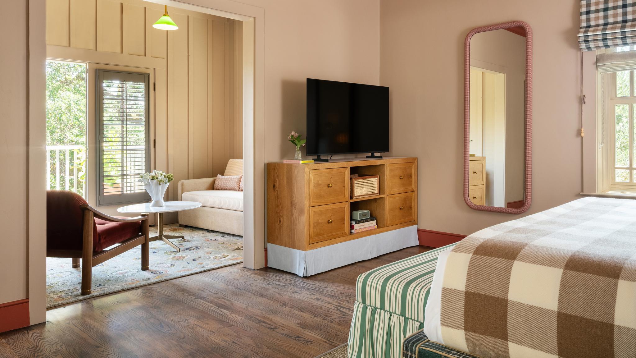 Cozy bedroom with TV, mirror, and balcony view