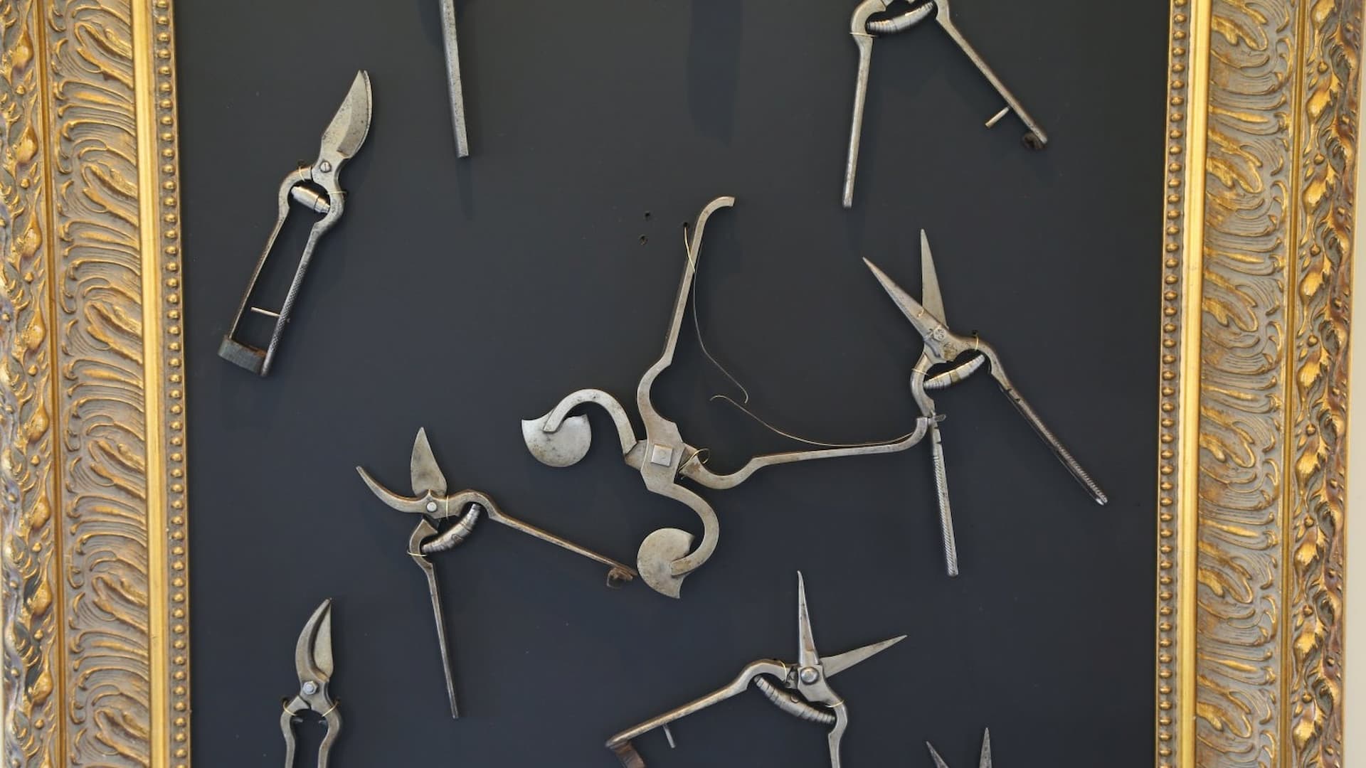 Decorative framed vintage scissors display on wall.