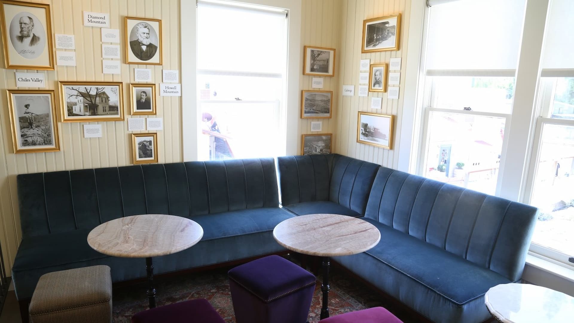 Room with blue couch, framed photos on walls.