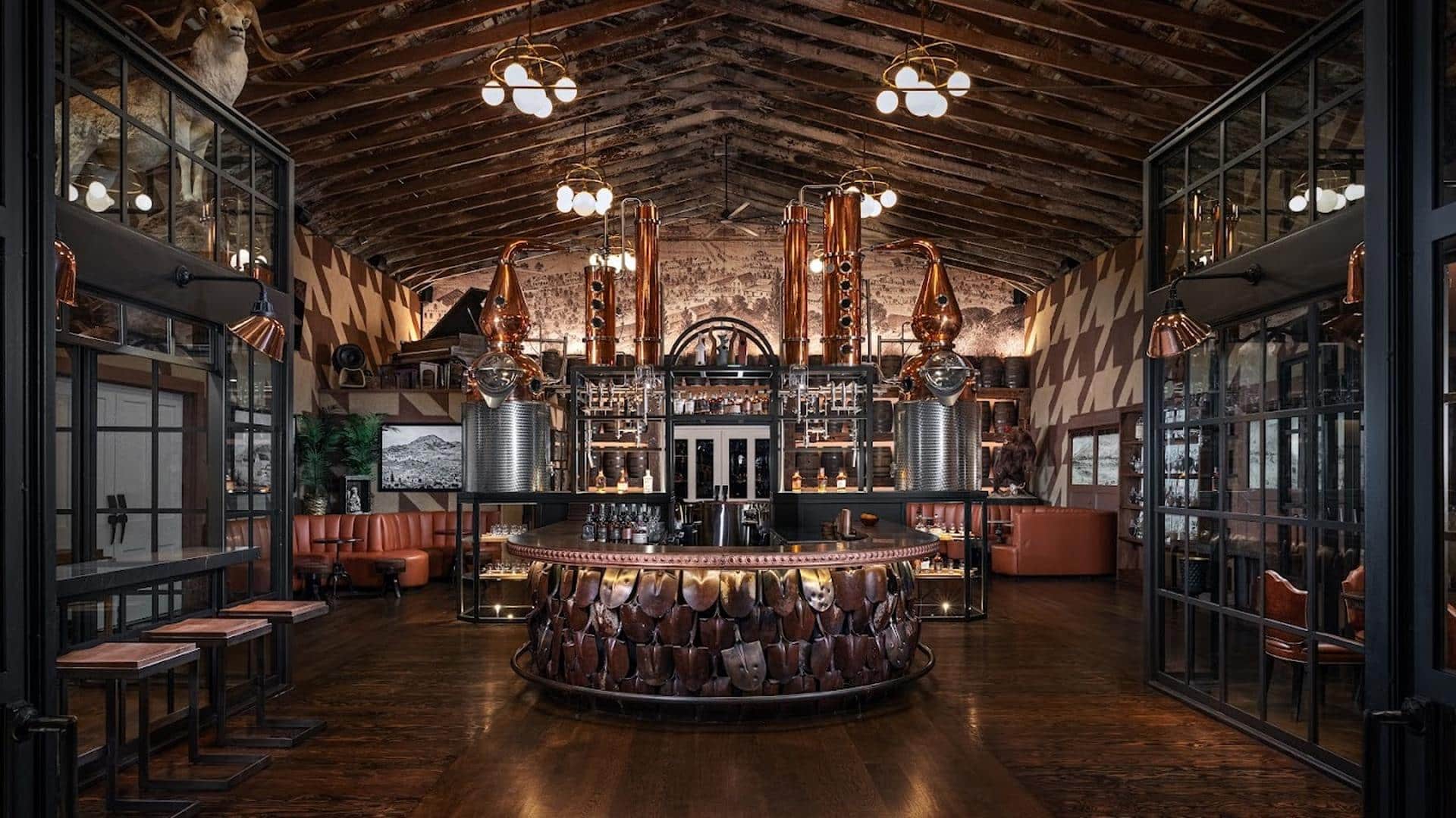 Rustic bar with copper distillery equipment and deer mount.