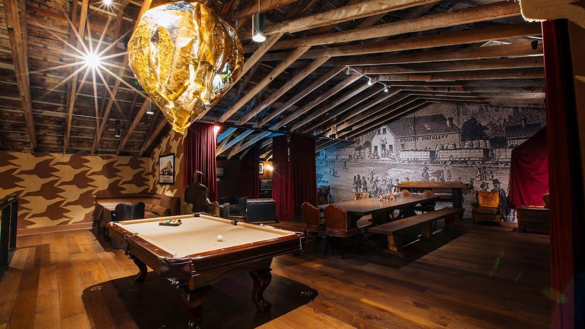 Cozy attic with pool table and mural.