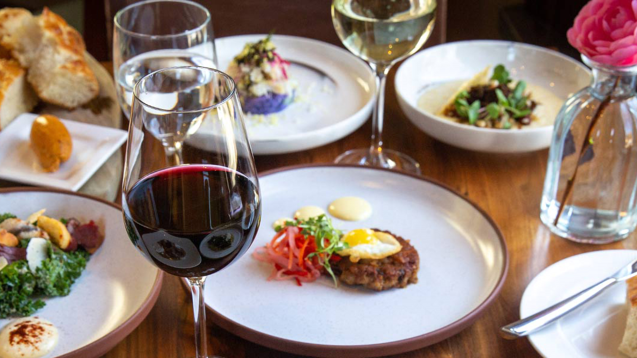 Gourmet meal with wine on a wooden table.