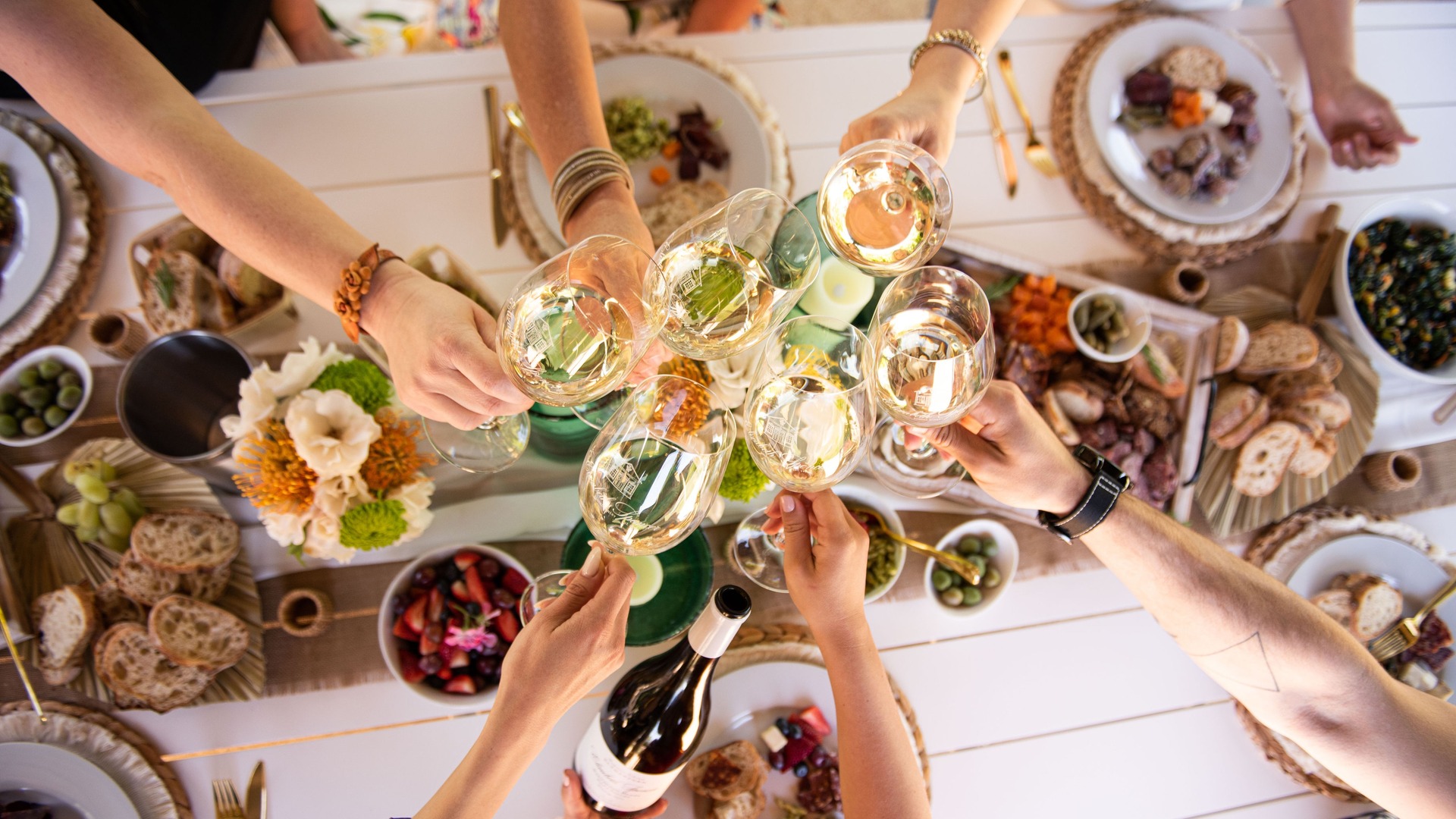 Friends toasting with wine at a festive dinner.