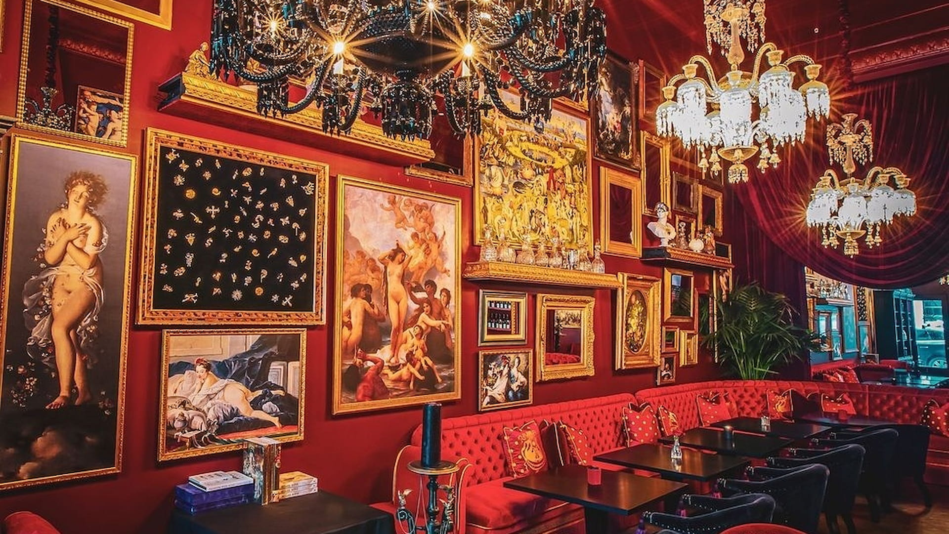 Luxurious dining room with ornate paintings and chandeliers.