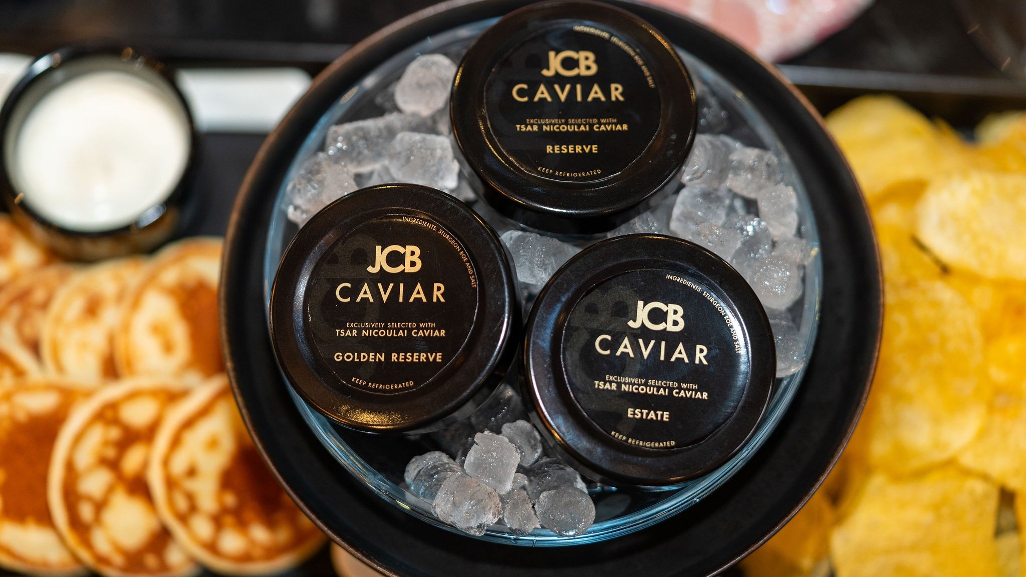 Three JCB caviar tins on ice.