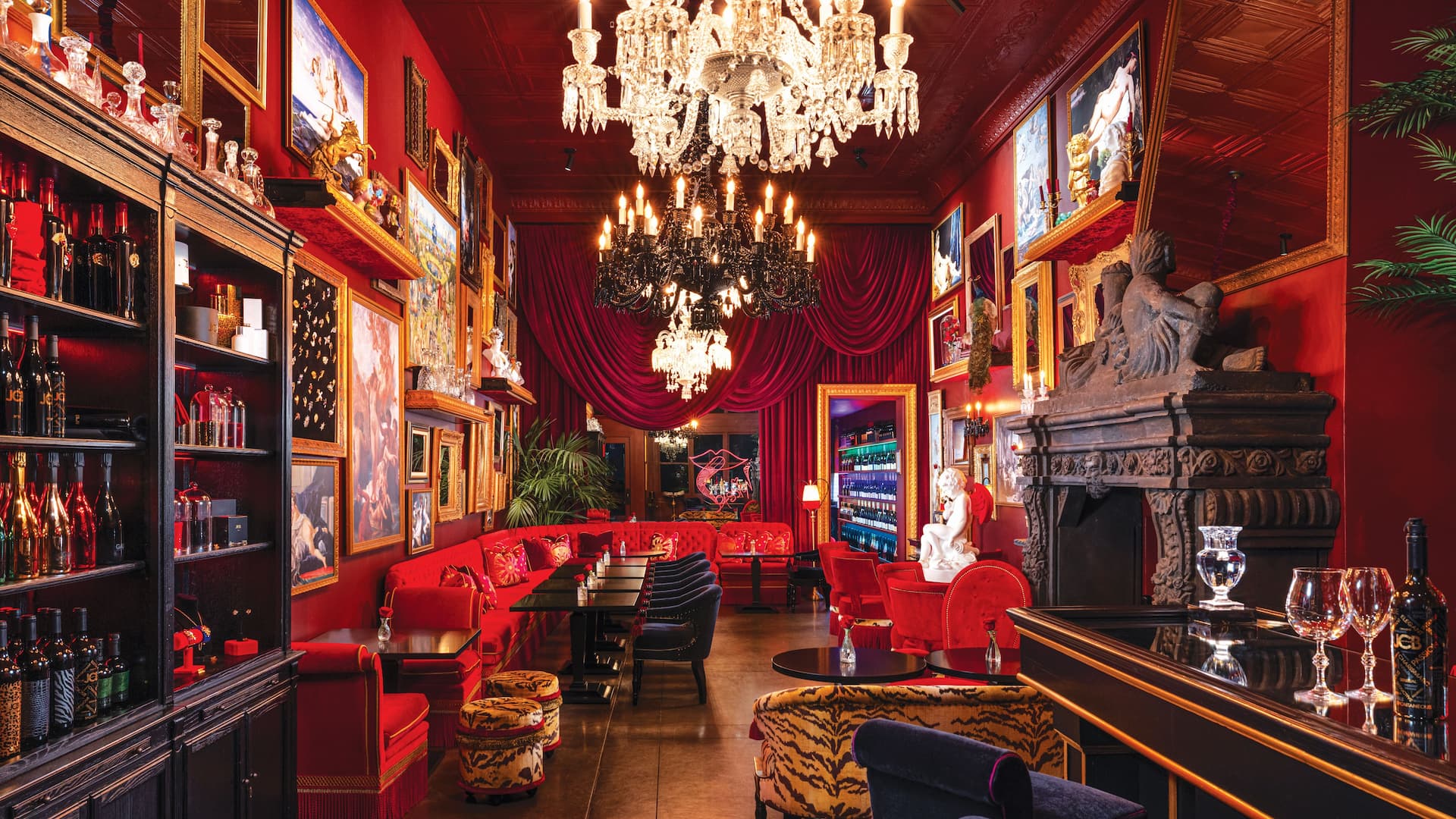 Opulent red interior with chandeliers and art.