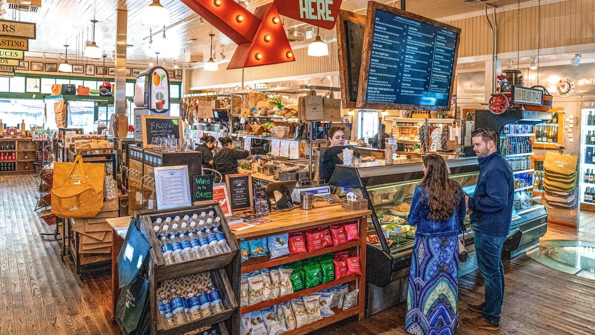 Shoppers in a busy gourmet food store.