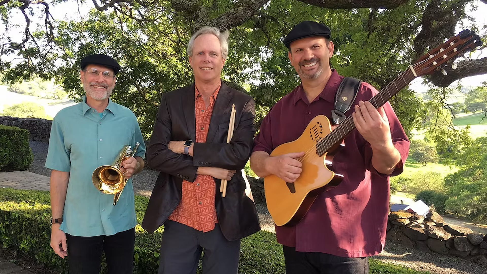 Three musicians outdoors with instruments