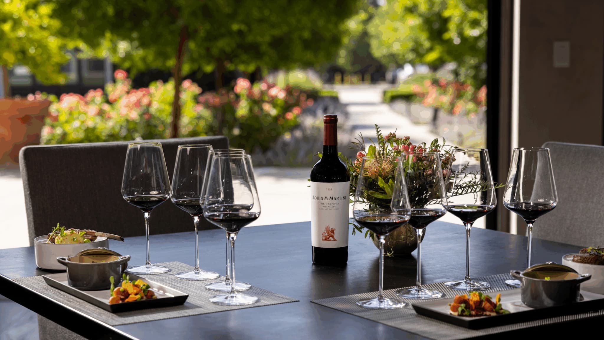Outdoor table with wine glasses and gourmet dishes