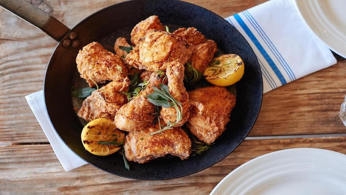 Fried chicken with lemon in a skillet