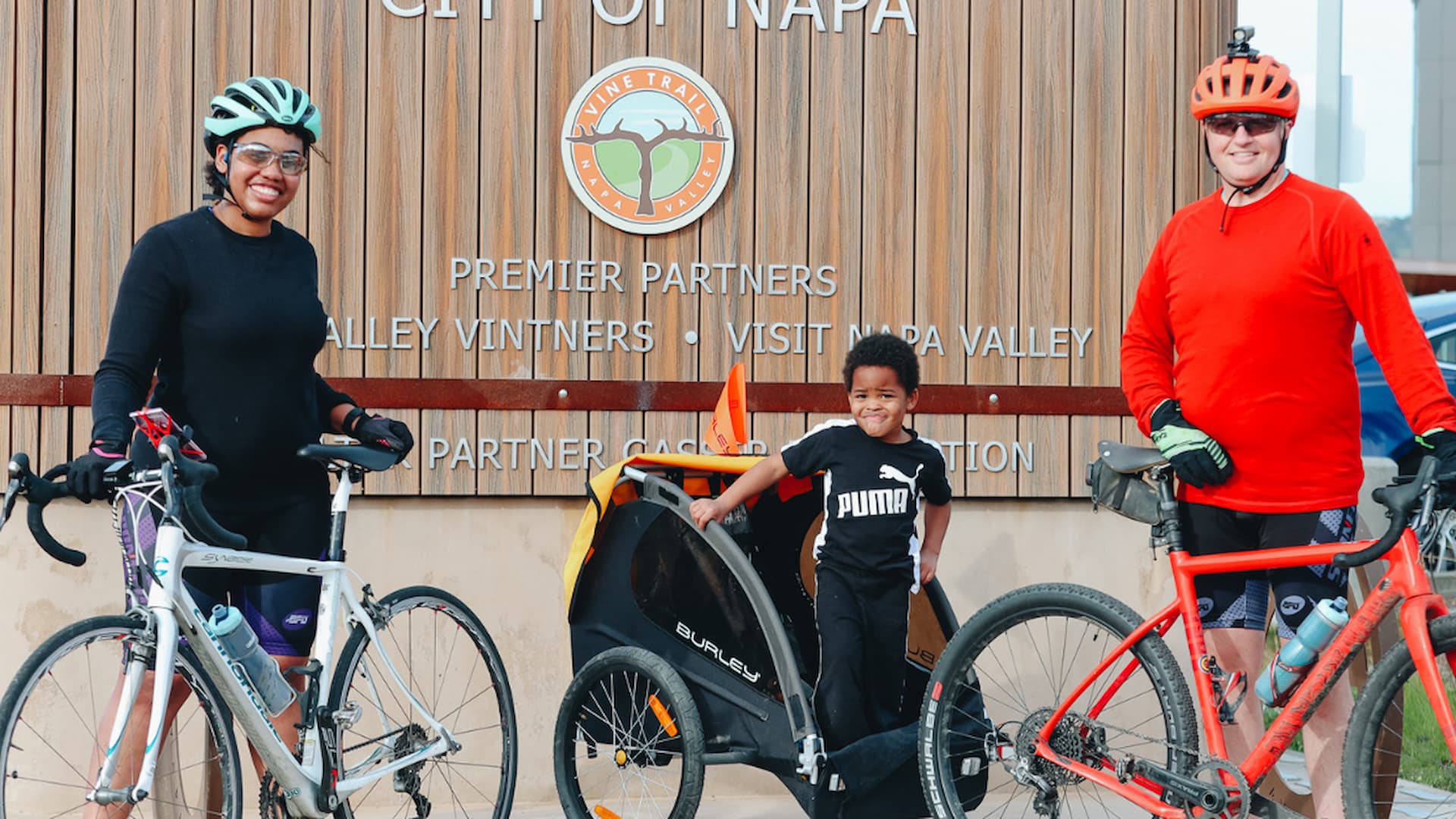 Family with bikes visiting Napa sign.