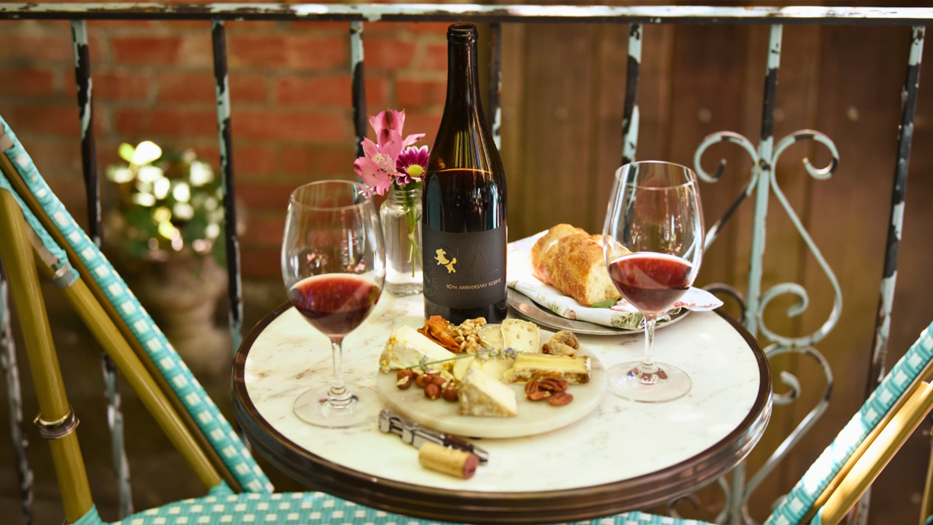 Wine and cheese spread on a cozy balcony table