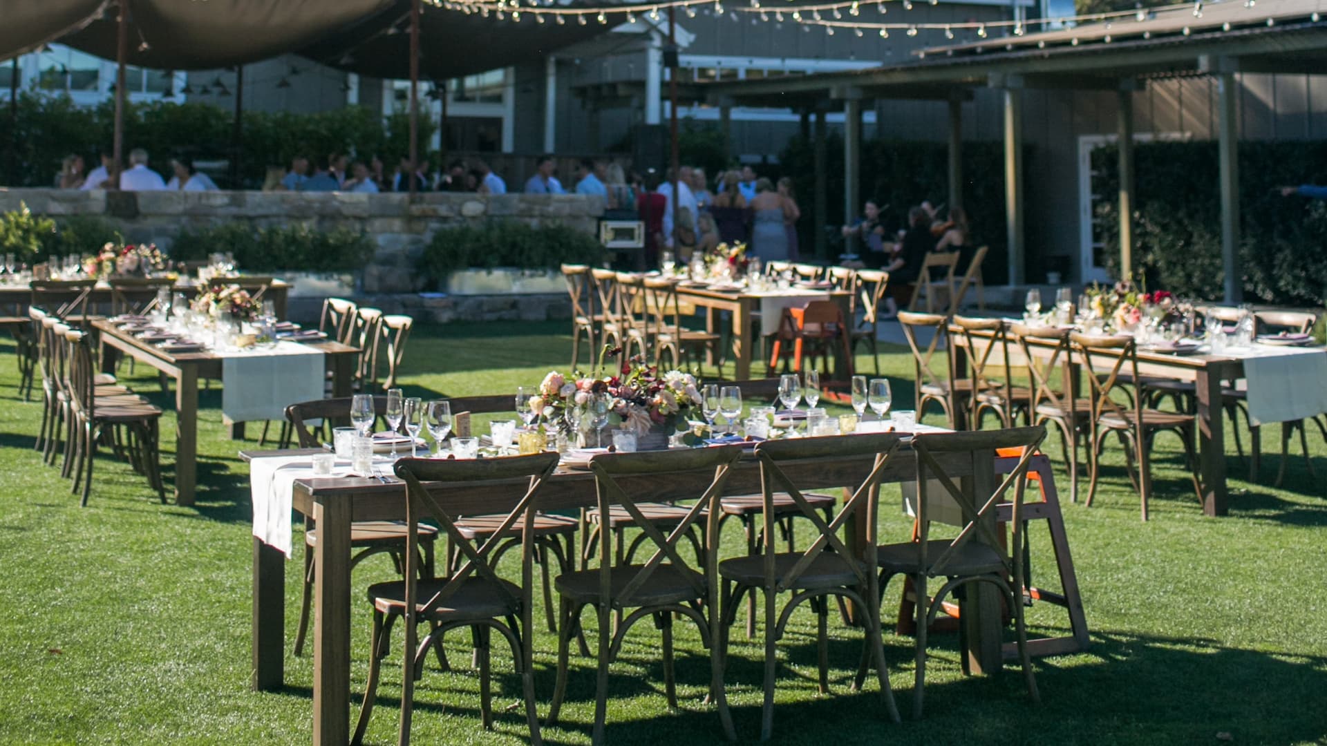 Outdoor wedding reception setup with tables and chairs.