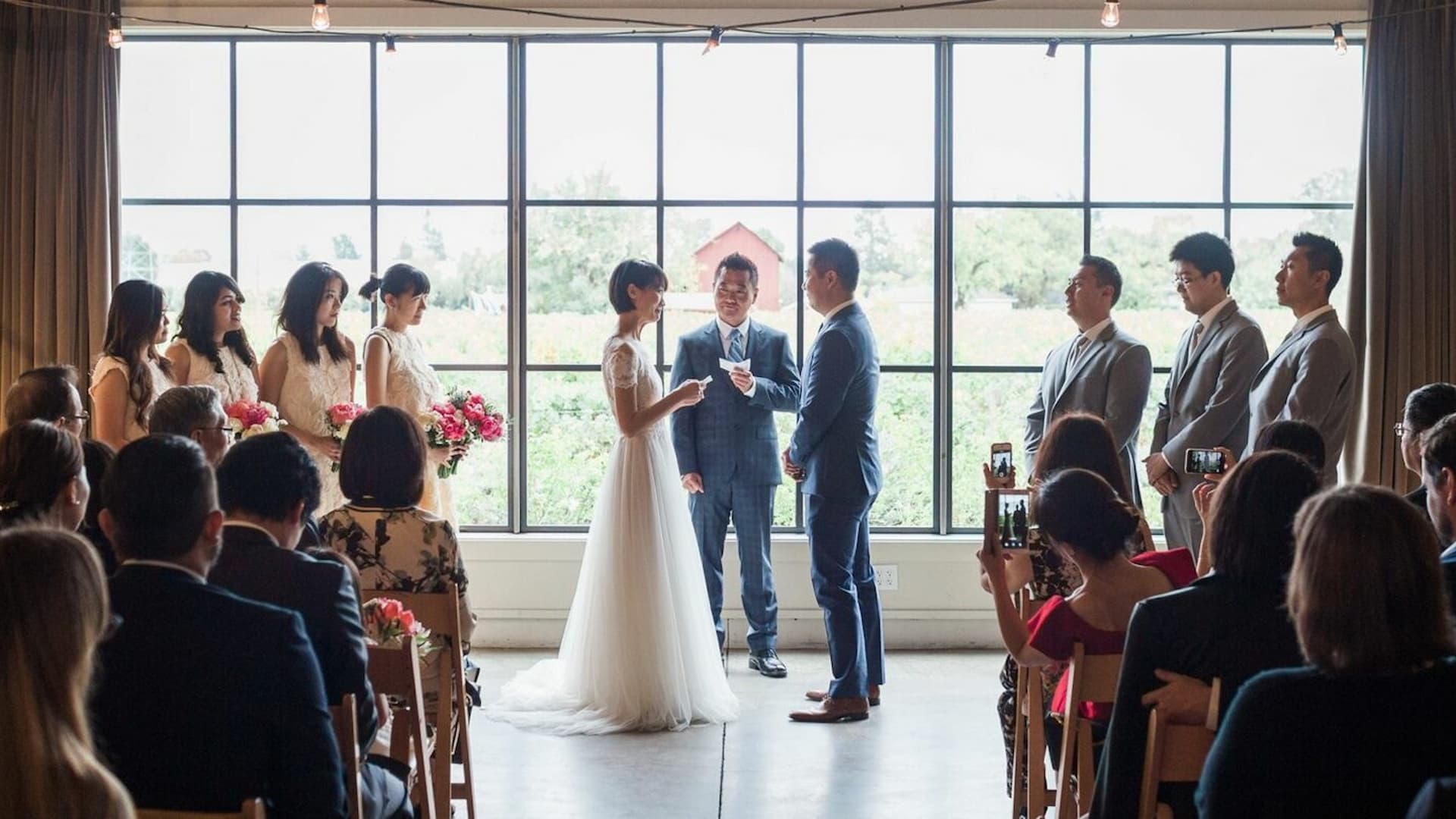 Indoor wedding ceremony with guests and wedding party.