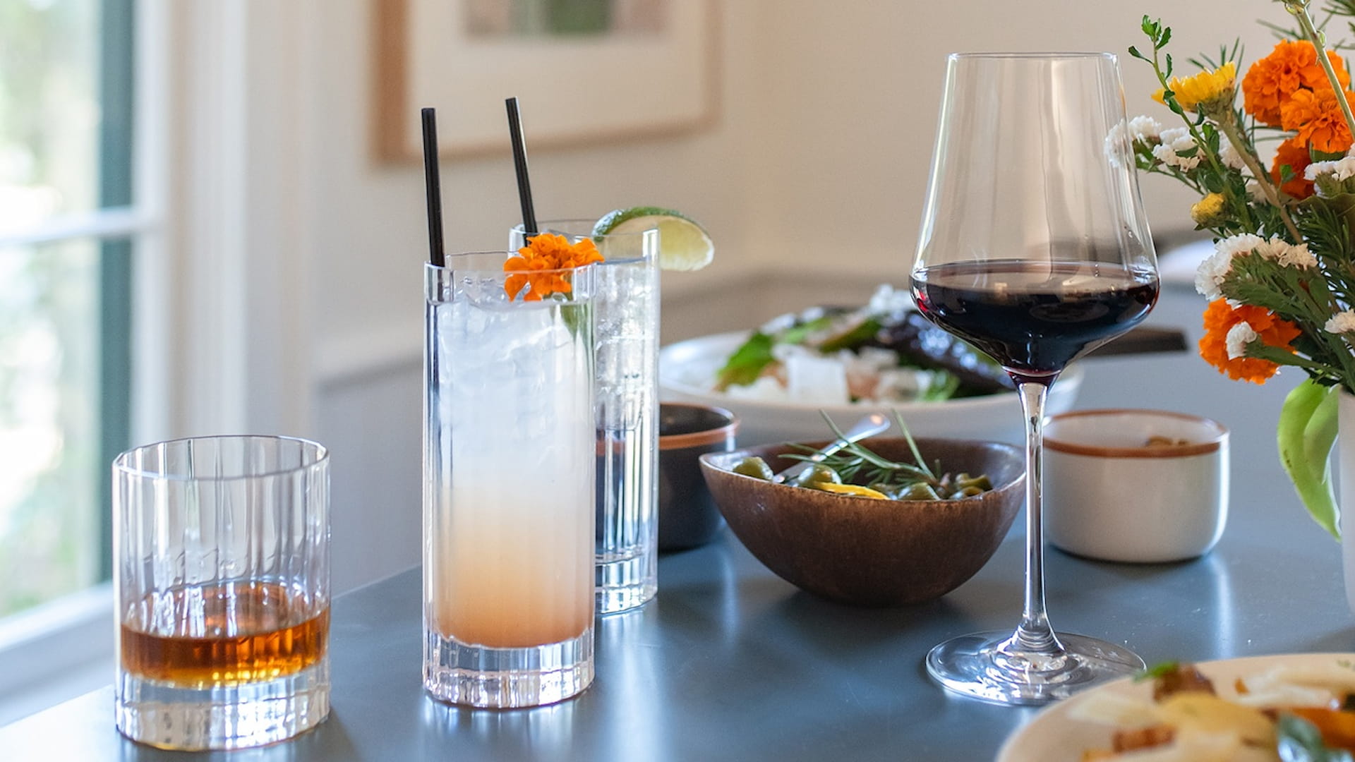 Assorted drinks and food on a table setting.
