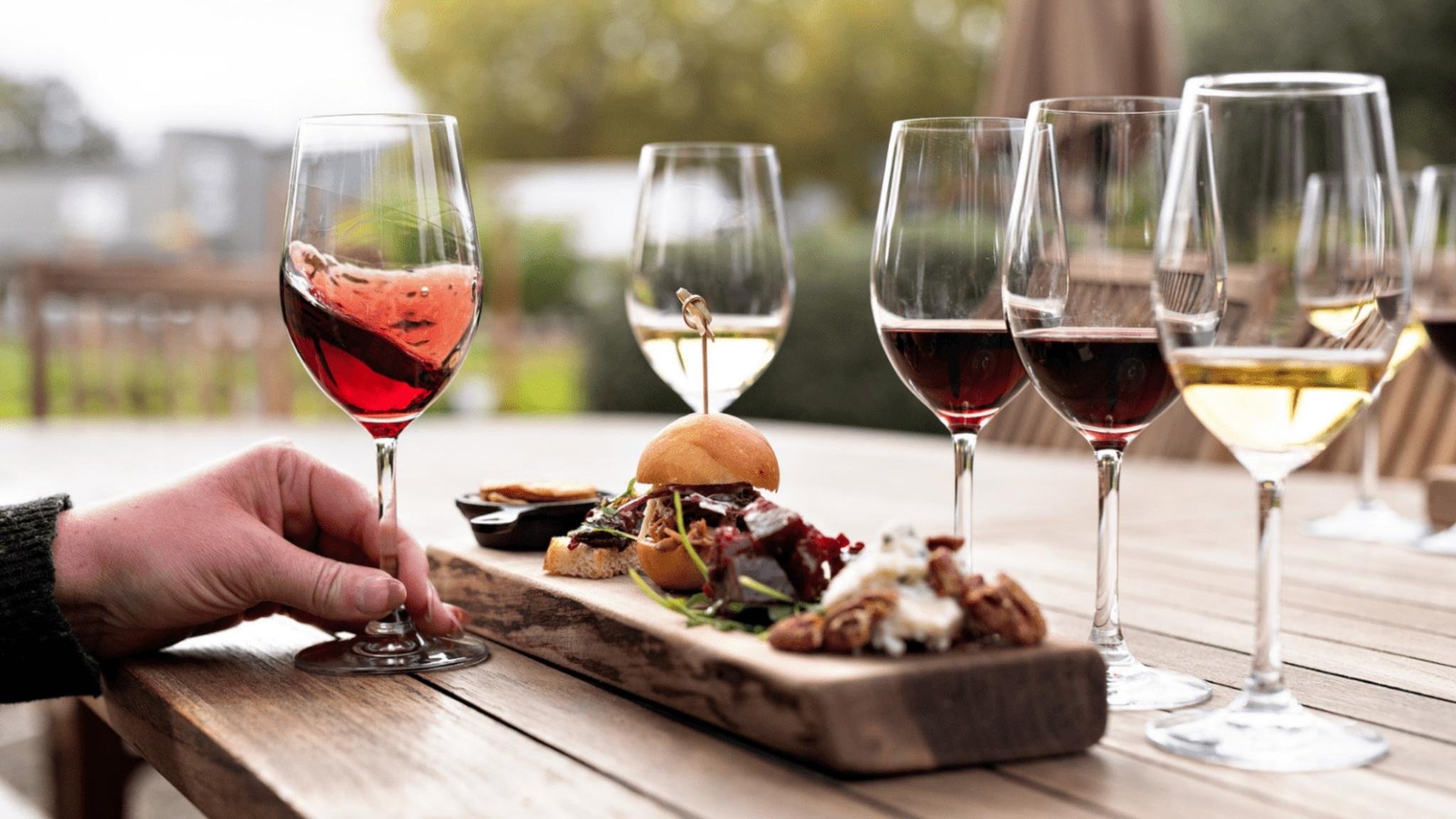 Wine glasses and appetizers on wooden table.