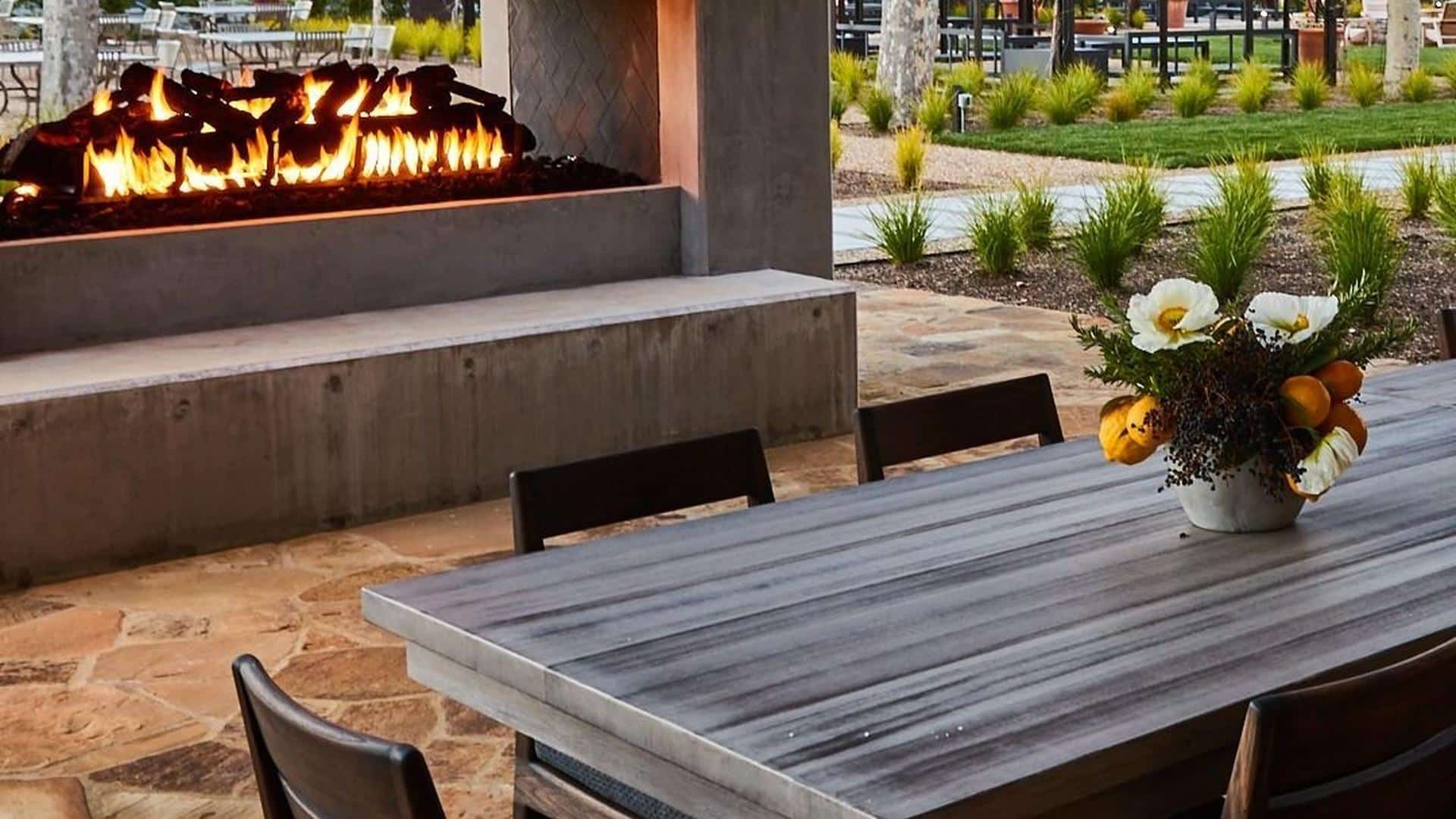 Outdoor patio with table, flowers, and fireplace
