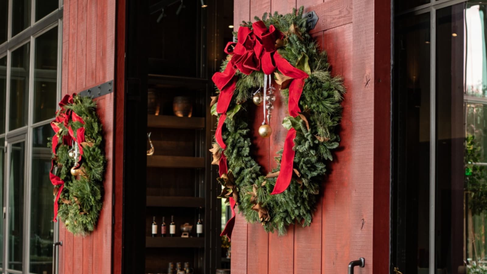 Christmas wreaths with red ribbons on wooden doors