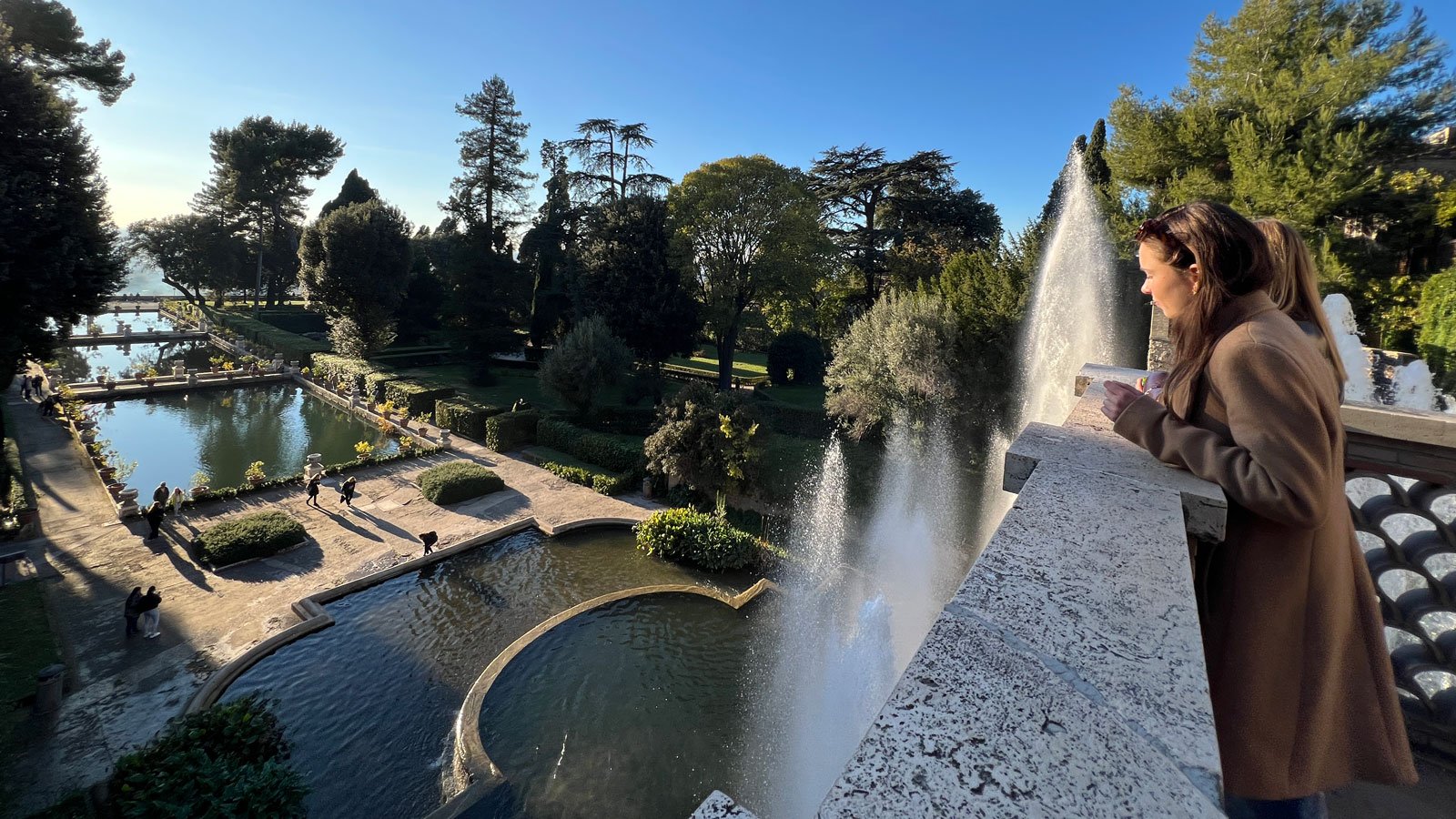 Woman enjoying scenic garden view with fountains