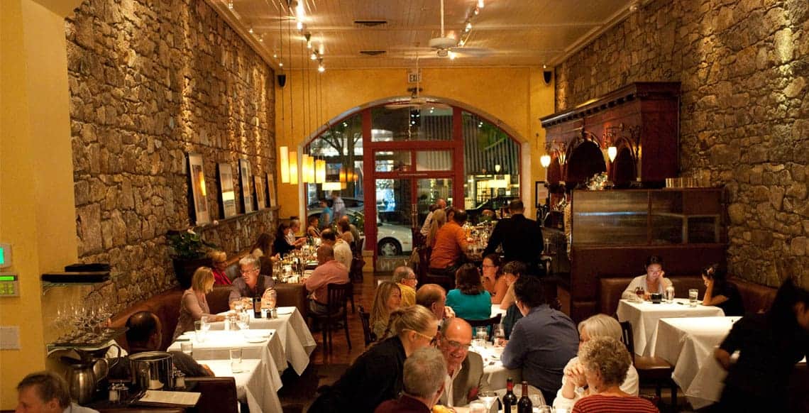 Busy restaurant with people dining indoors.