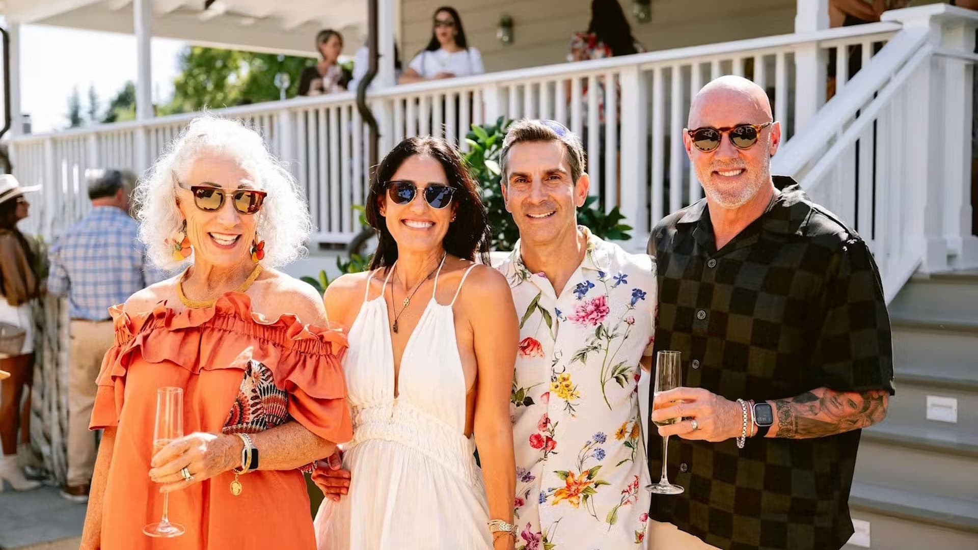 Four adults smiling at outdoor celebration