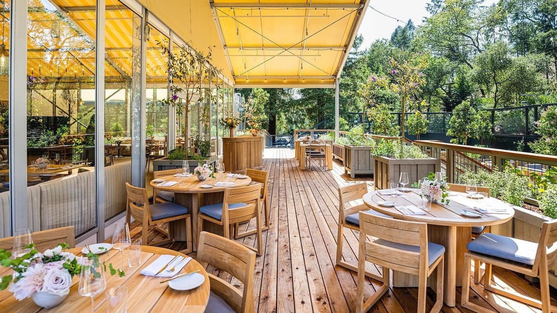 Outdoor dining area with wooden tables and chairs.