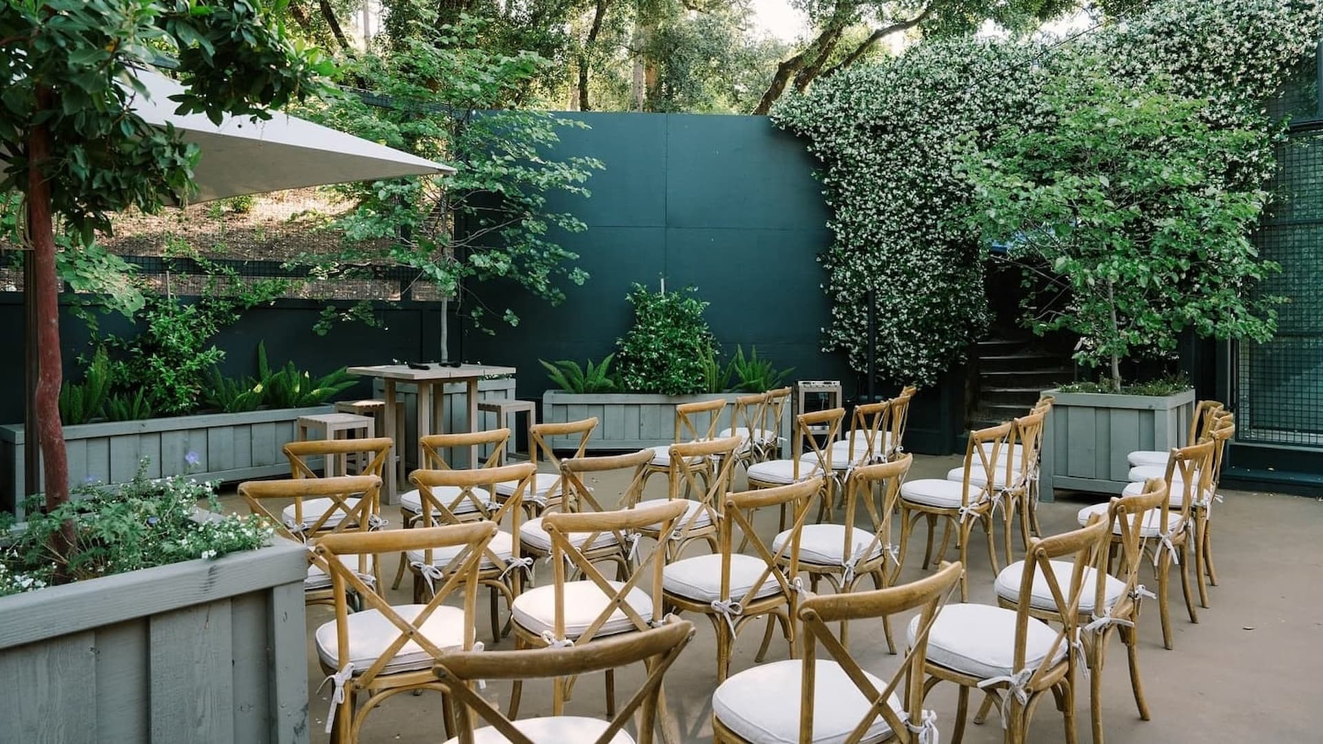Outdoor garden event setup with wooden chairs