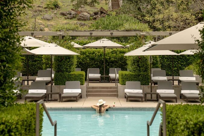 Woman relaxing in luxury pool with loungers