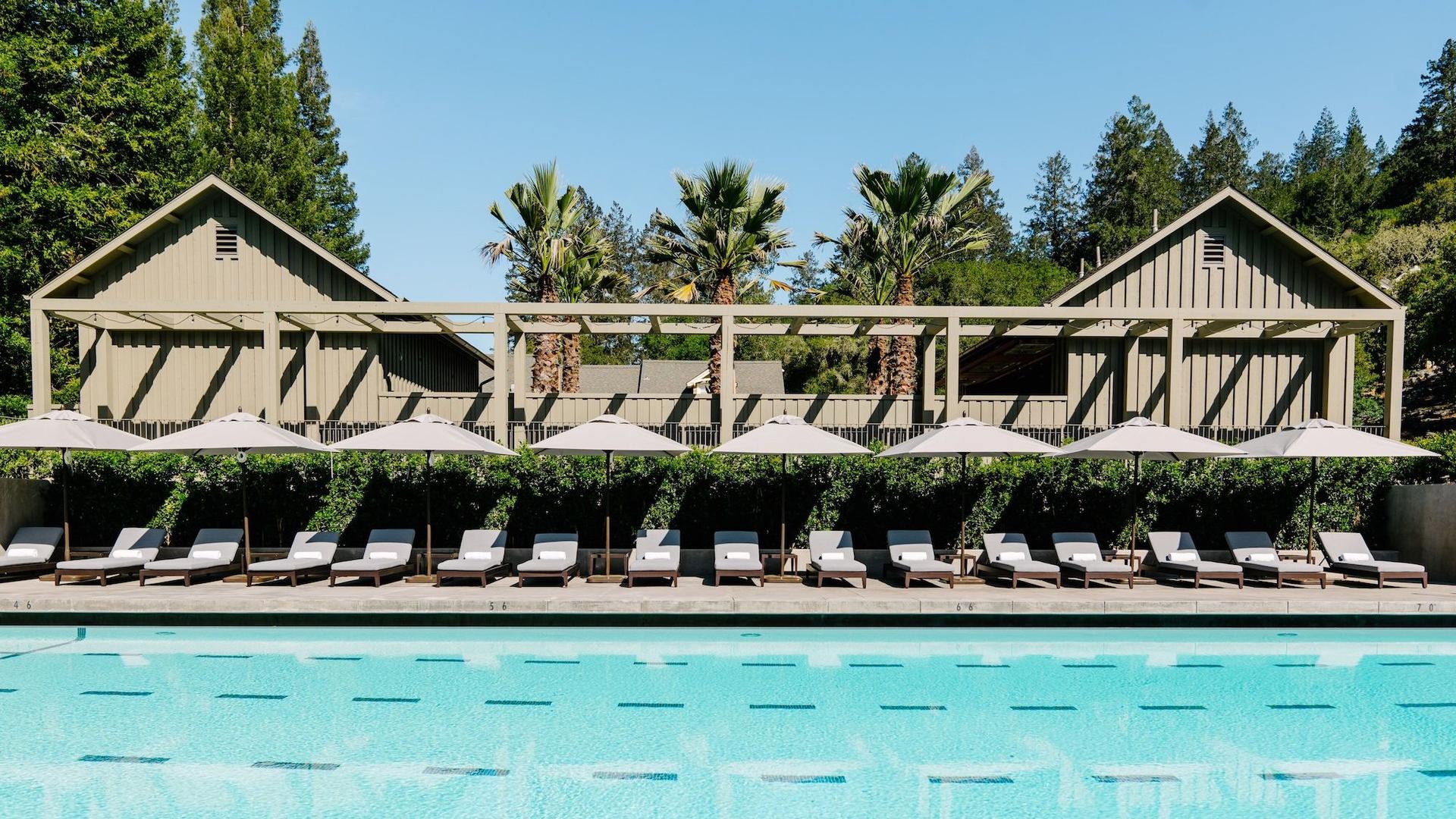 Resort pool with lounge chairs and umbrellas.