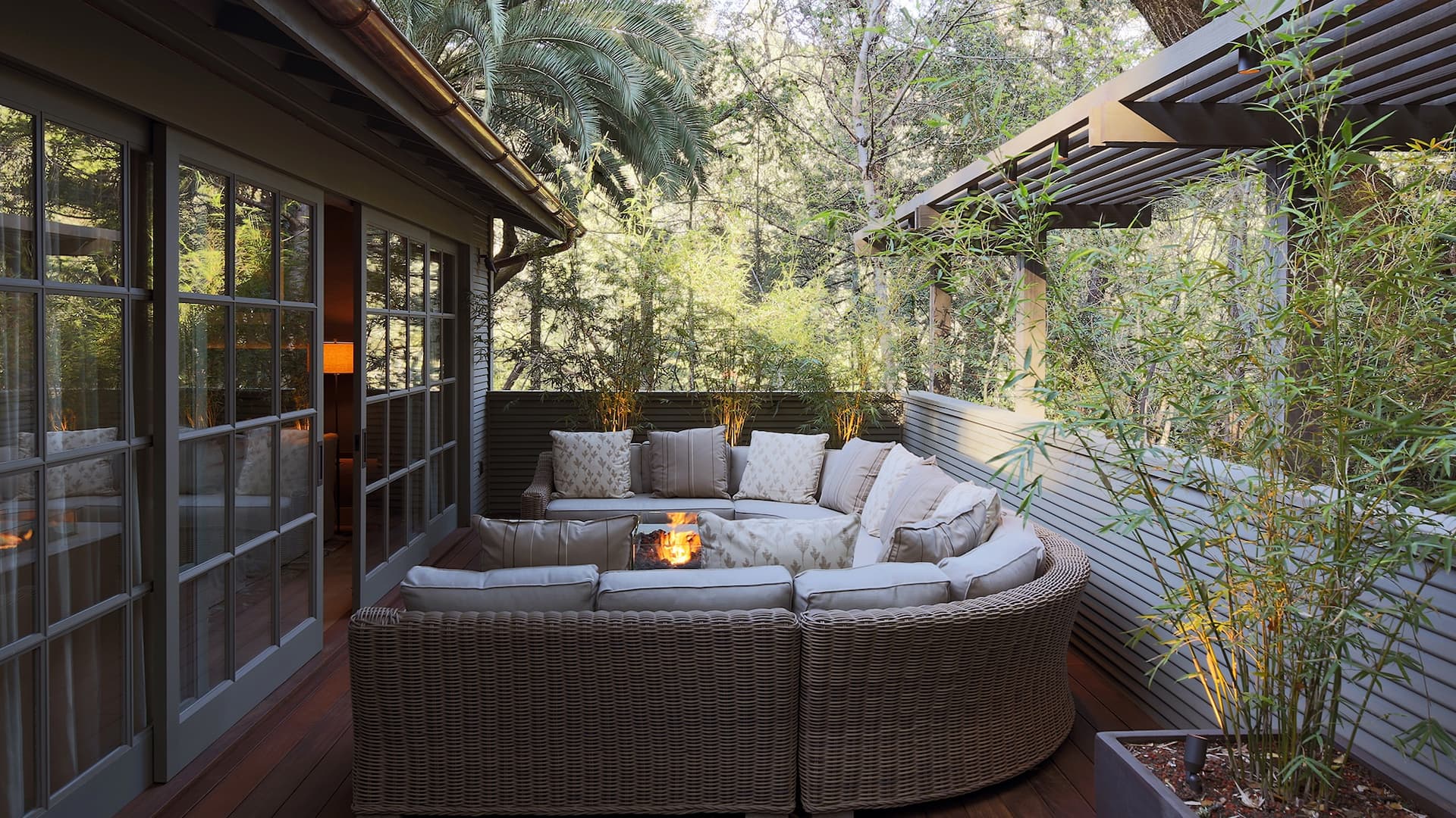 Cozy patio with wicker furniture and fire pit.