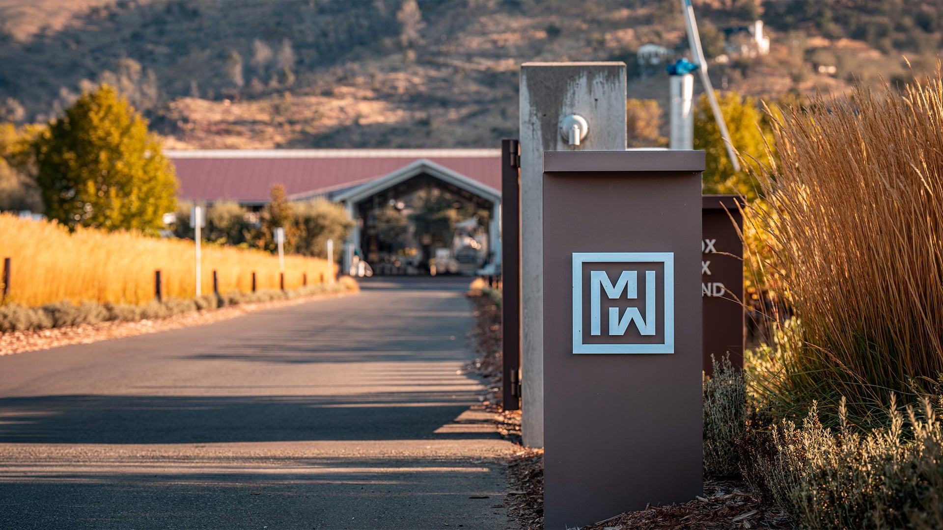 Modern gate entrance leading to rural hillside building