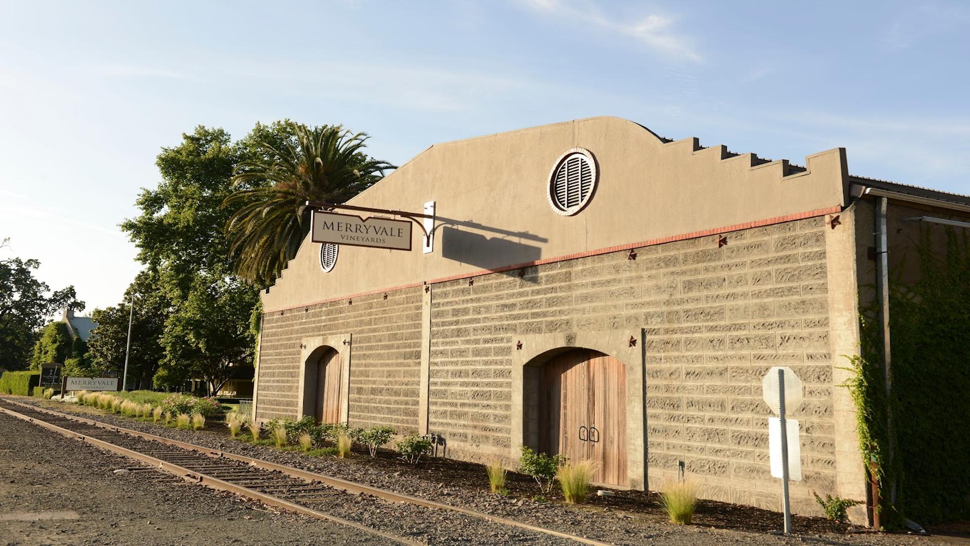 Merryvale Vineyards rustic winery building with palm trees.