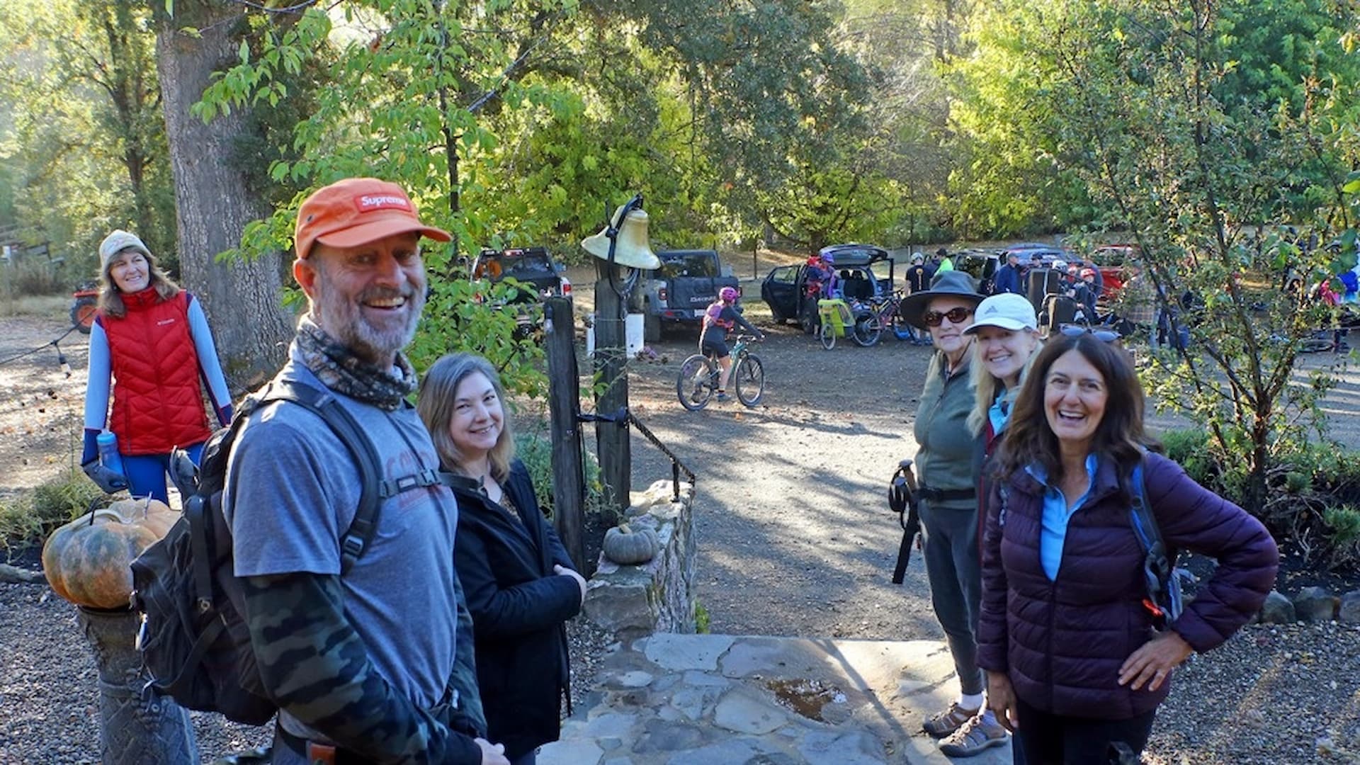 Group of hikers smiling outdoors with bicycles around.