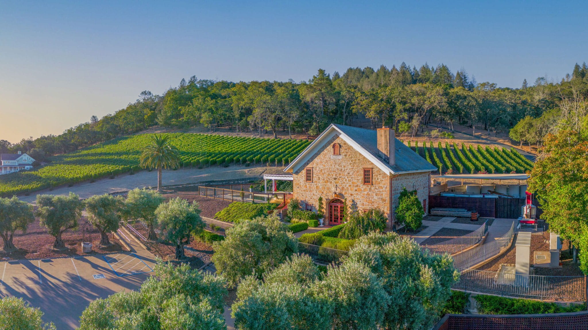 Scenic vineyard with stone building and lush greenery.