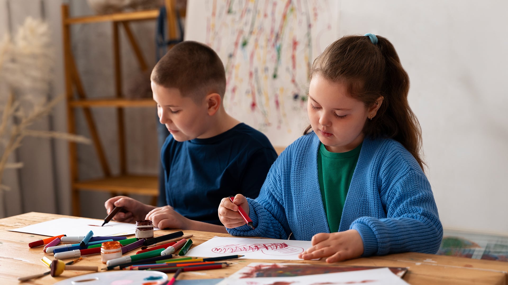 Two children drawing with colorful markers at a table